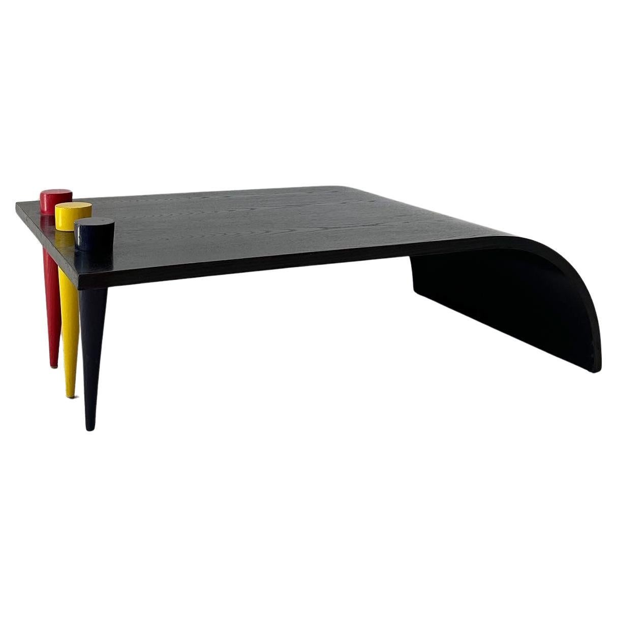 ebonized wood waterfall coffee table with primary color conical legs For Sale