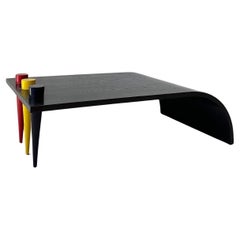 Retro ebonized wood waterfall coffee table with primary color conical legs