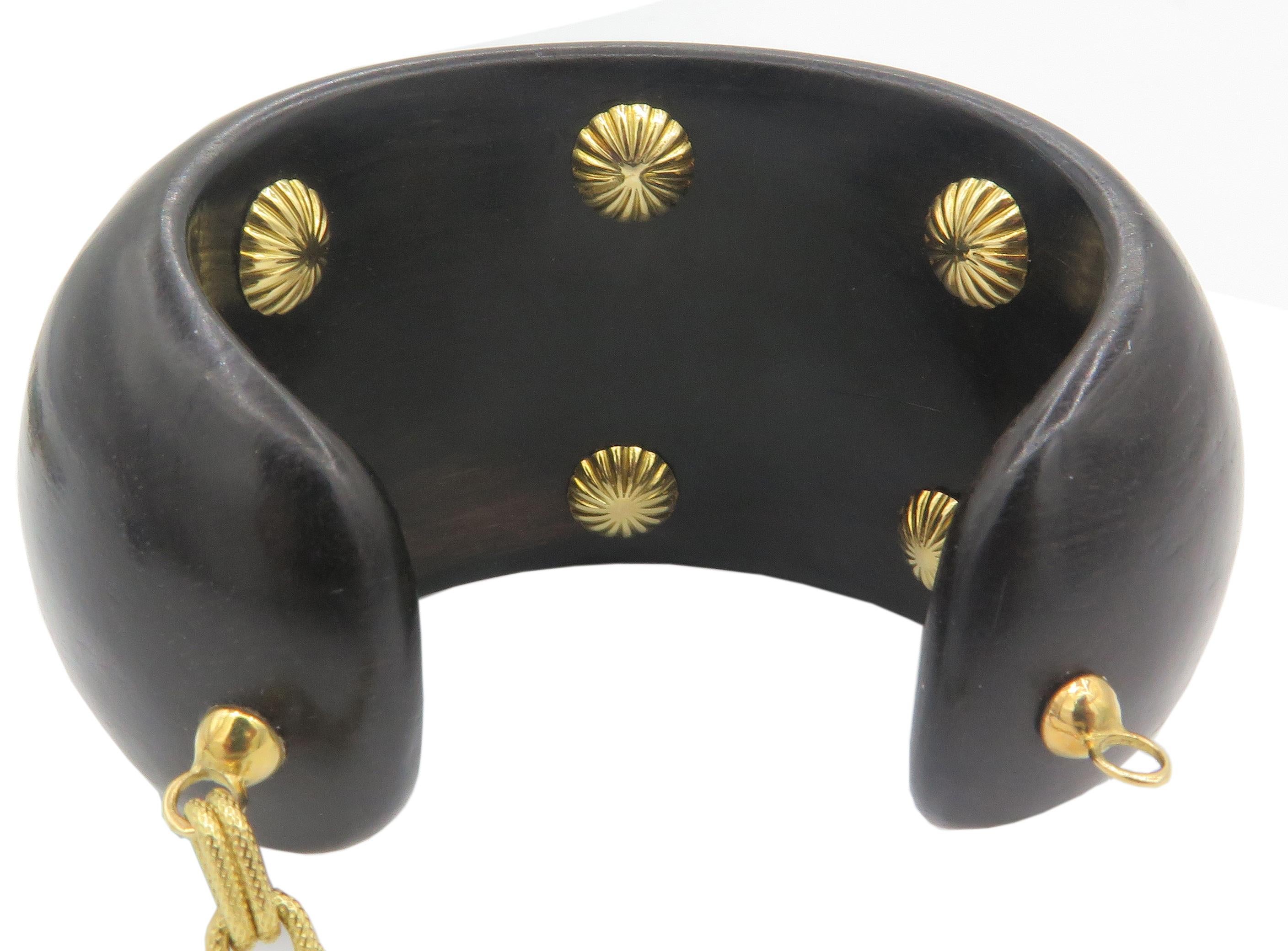 Beautiful, Ebony 18K yellow gold cuff bracelet. This beautiful bracelet is made out of Ebony, and features a cabochon Agate in the center mounted ontop of a 18K textured yellow gold bezel. The, bracelet includes a yellow gold chain link in the back