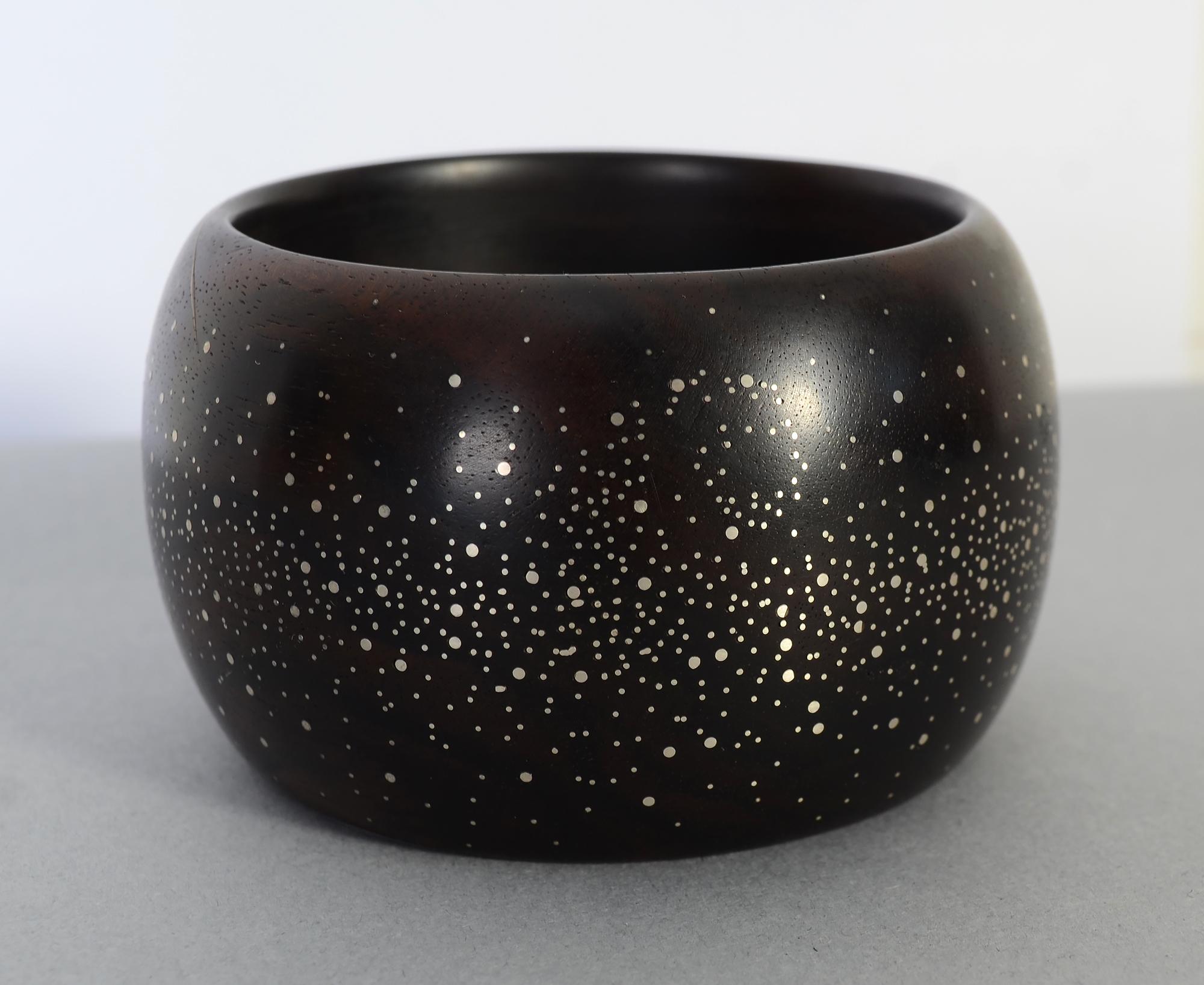 Bold and unusual wide cuff bracelet of ebony impregnated with tiny dots of silver. The bracelet was made by South African jeweler, Vincent Lourens.
The slip on bangle has an inside diameter of 2 5/8 inches. It is 2 1/8 inches from front to back. The