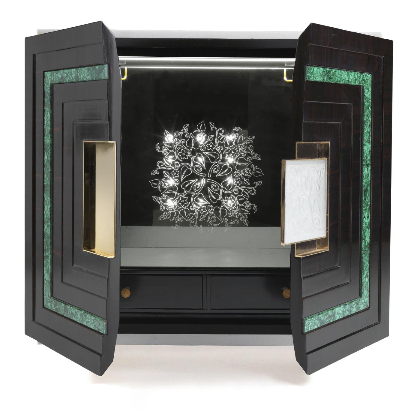 This magnificent cabinet will be a precious addition to a living room and an ideal place to store bottles, glasses, and other necessities to serve drinks. The structure in black nickel features tall and slender legs connected with brass elements and
