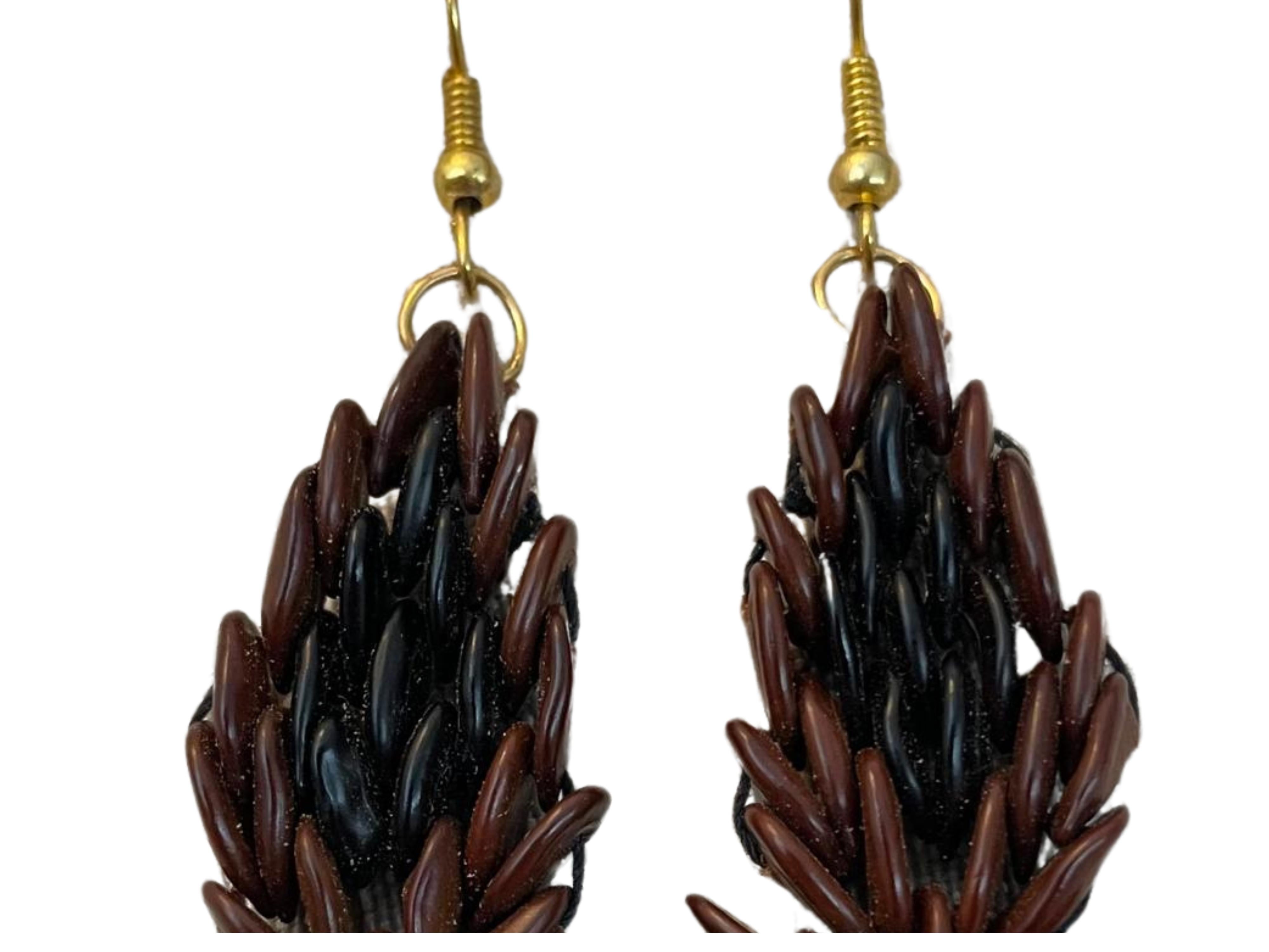 Introducing the Botanique Ebony Blossom Earring —a masterpiece of heritage ware meticulously handcrafted from wild tamarind seeds. This intricately handmade earring, weaves together natural brown seeds with ebony hues on the upper central segment