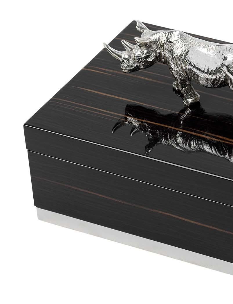 Characterized by a simple shape and prized materials, this superb box combines the rich dark Macassar ebony frame with the shimmer of the silver plated brass Rhinoceros sculpture that adorns the lid. An elegant addition to a living room console,