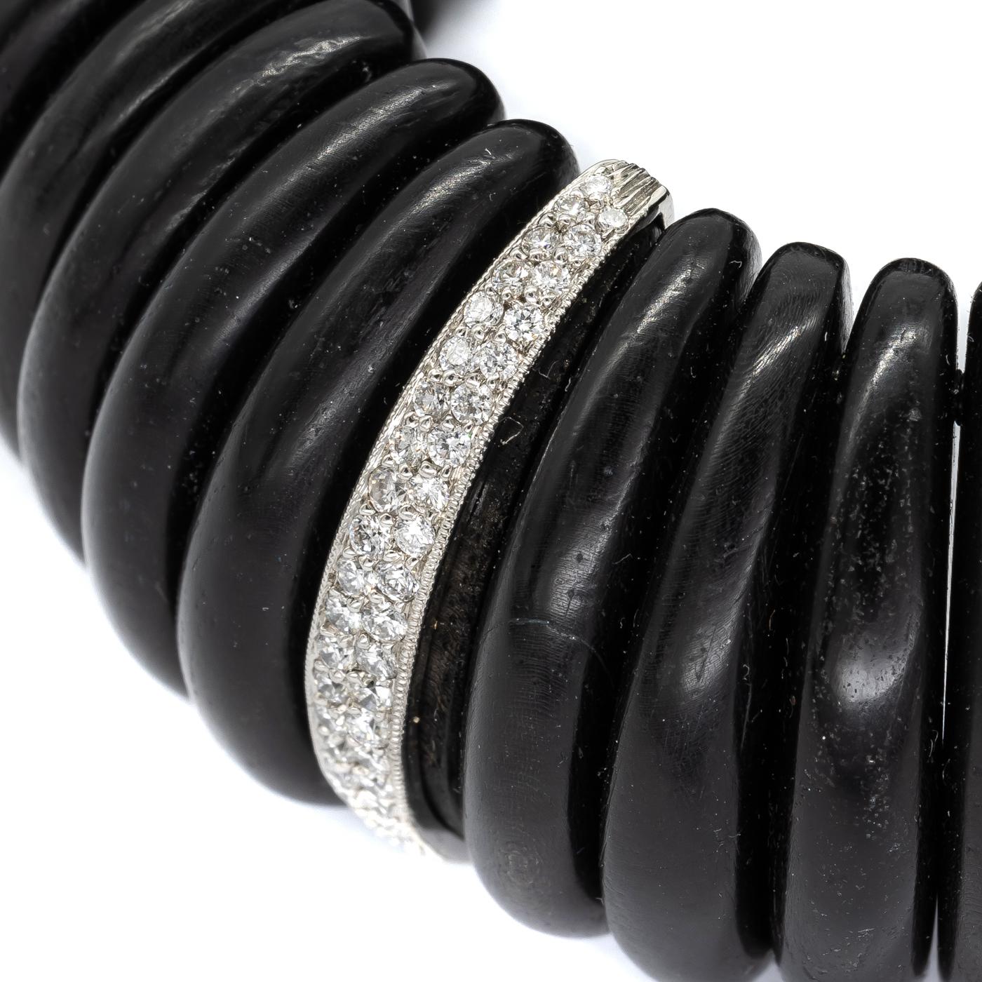 An ebony and diamond cuff bracelet, designed as a repeating pattern of eight, ebony segments, spaced by a diamond link, which is pavé set with two rows of graduated, round brilliant-cut diamonds, in platinum settings, weighing an estimated total of