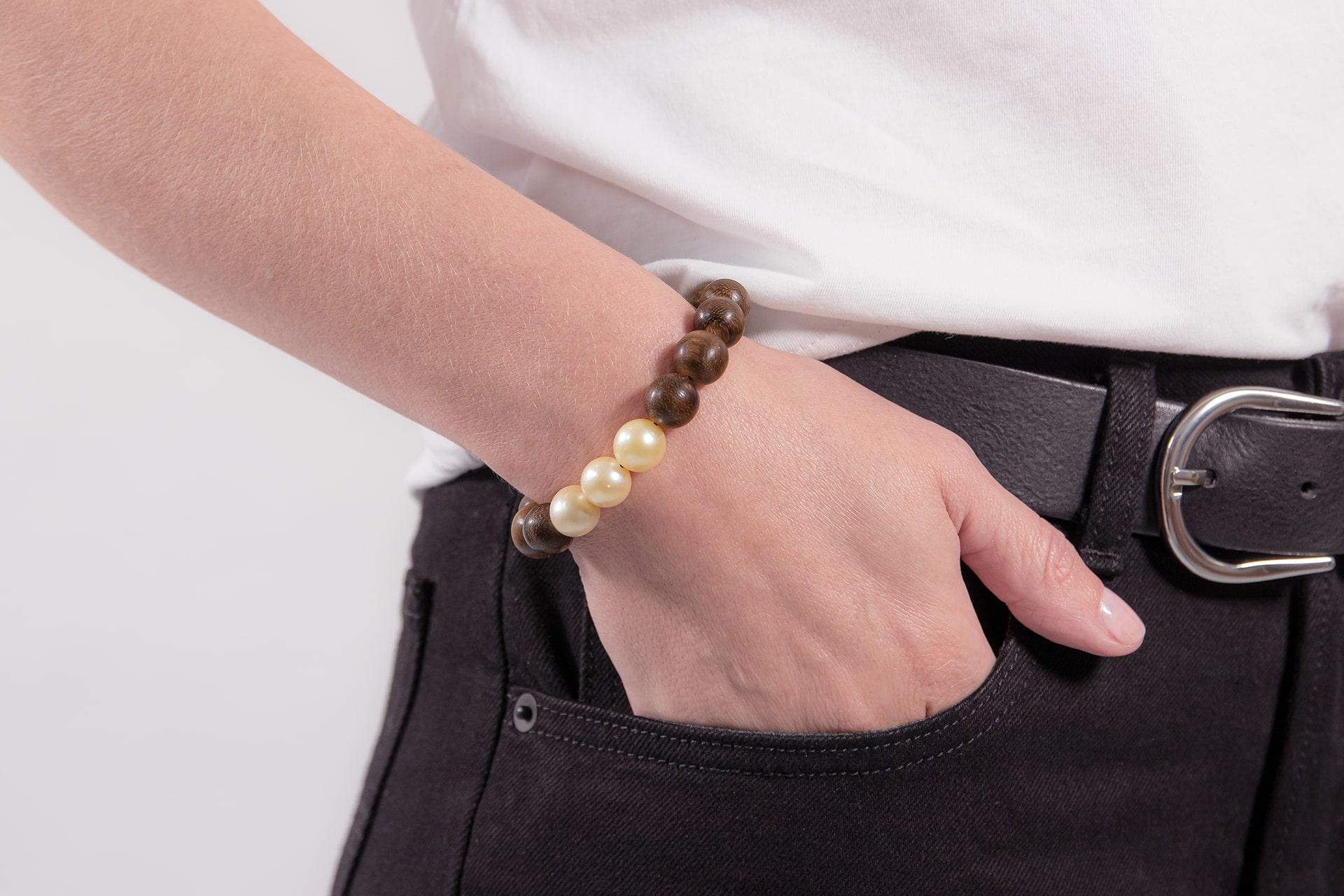 Experience the allure of our exquisite bracelet featuring ebony beads and three exclusive golden South Sea pearls. This piece stands out for its elegant yet understated simplicity. The ebony beads are incredibly lightweight, ensuring they are almost