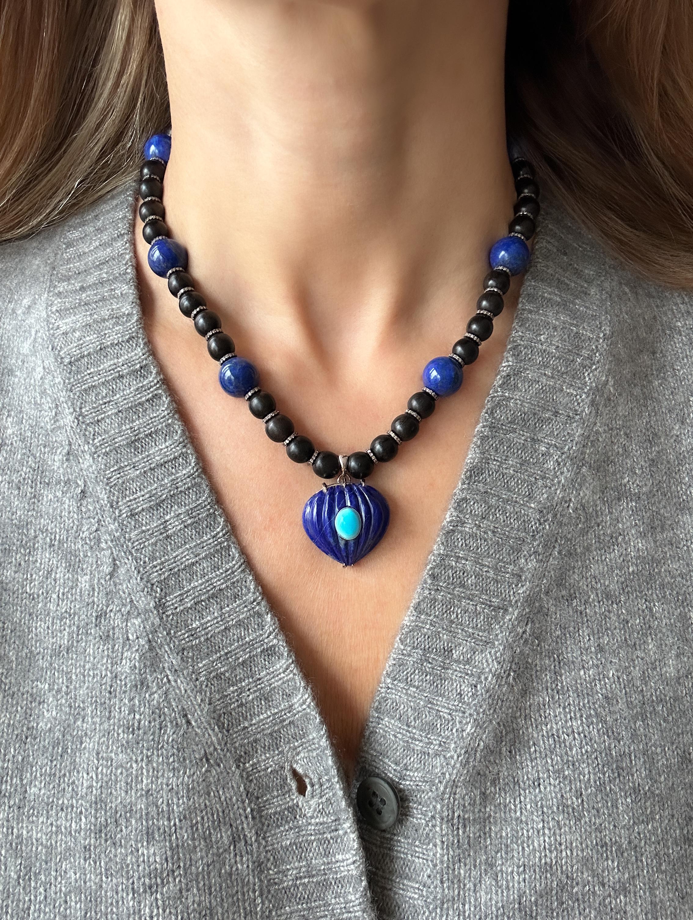 The necklace is composed of ebony and lapis lazuli beads separated by diamond rondelles, a lapis lazuli carved pendant set in white gold prongs, and incrusted with a turquoise cabochon. The diamond rondelles are set in S/S and the oval turquoise