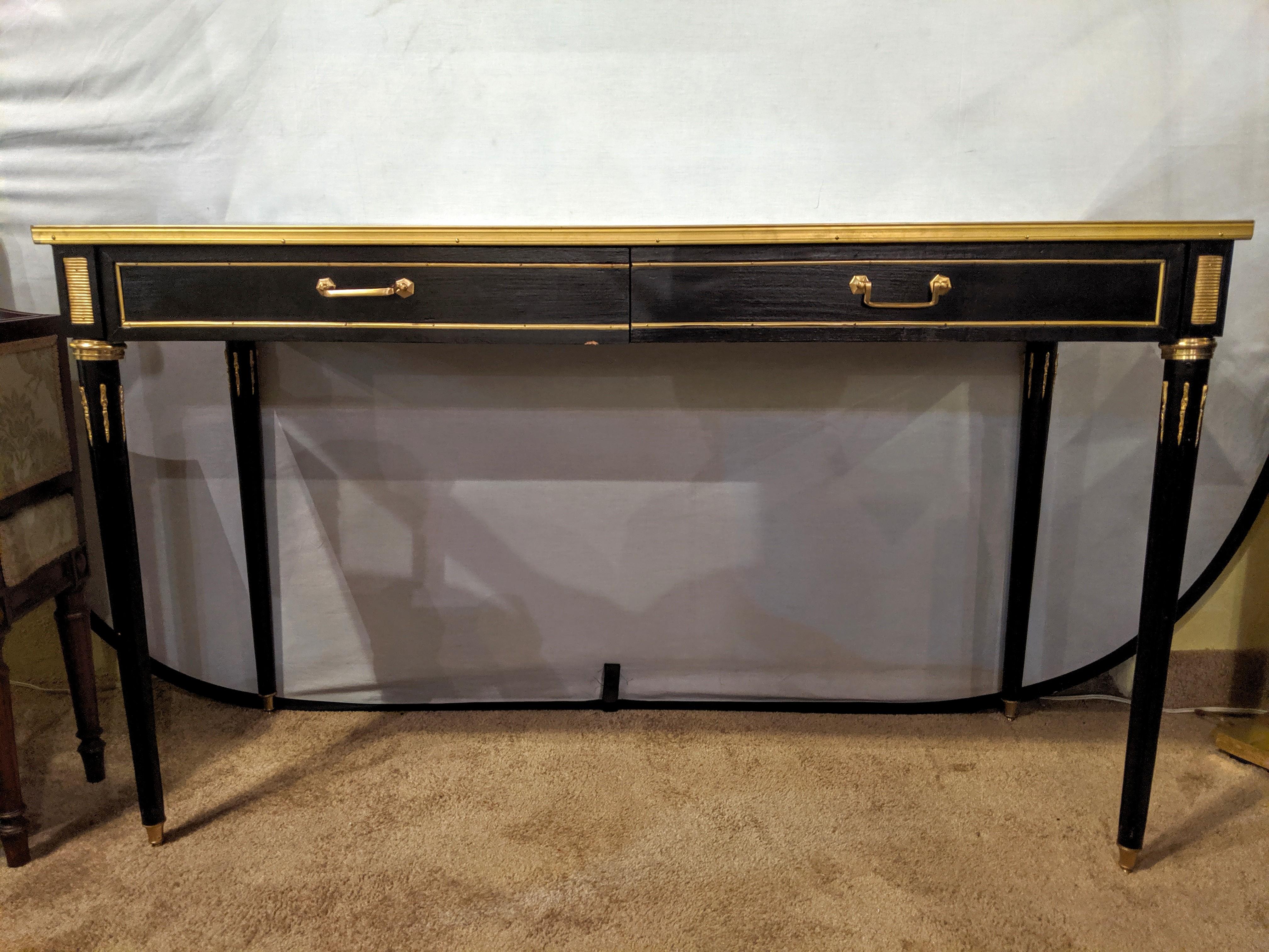 Pair of ebony Maison Jansen style mirror top 2-drawer console with bronze mounts. Each having tapering legs with bronze mounts and cookie cutter corners. Each with an clean mirror top.