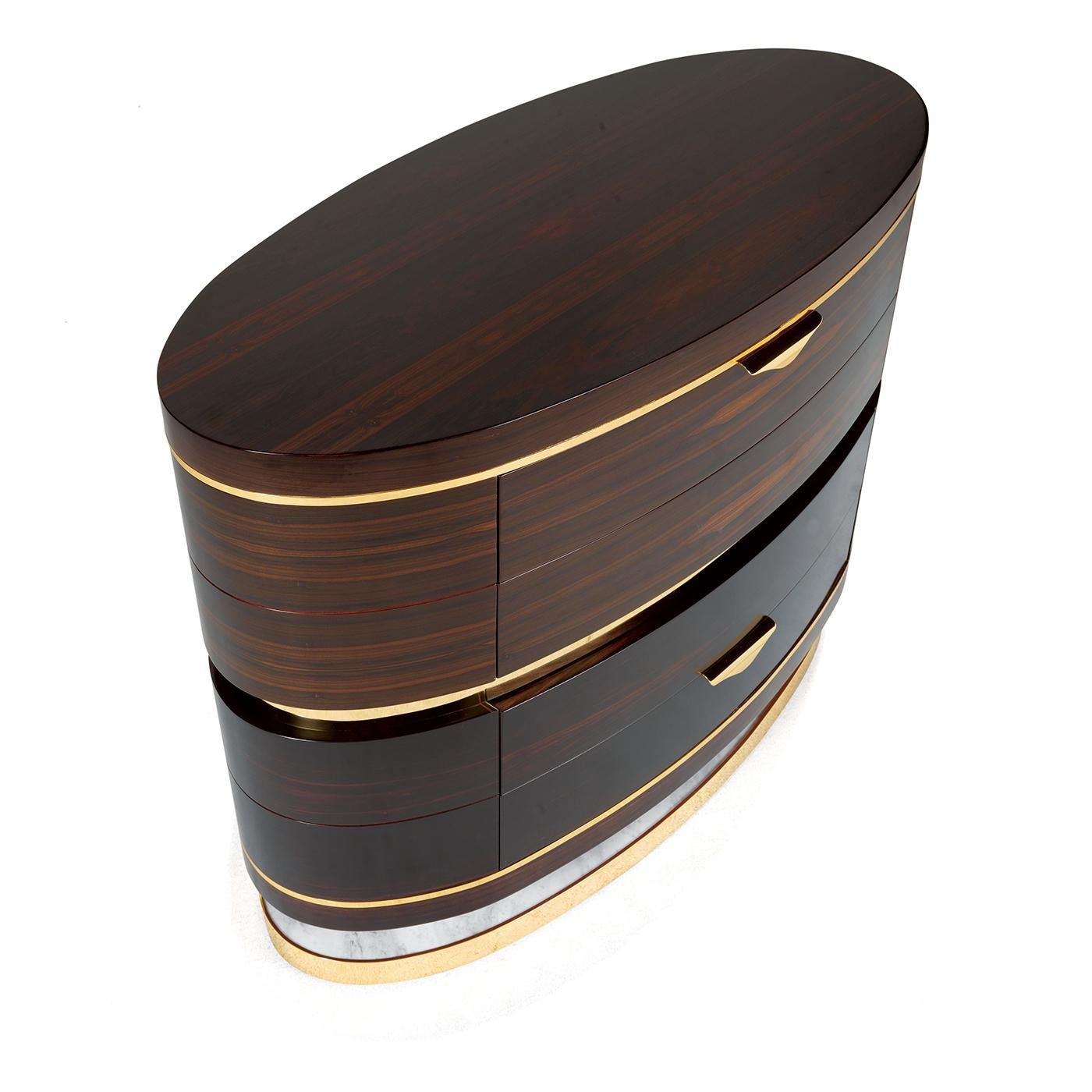 Combining the dark elegance of ebony with the strikingly large grain of the ziricote wood, this oval chest of drawers is a stunning piece of functional decor that will enrich the look of any bedroom. The bold structure rests on a base in brass,