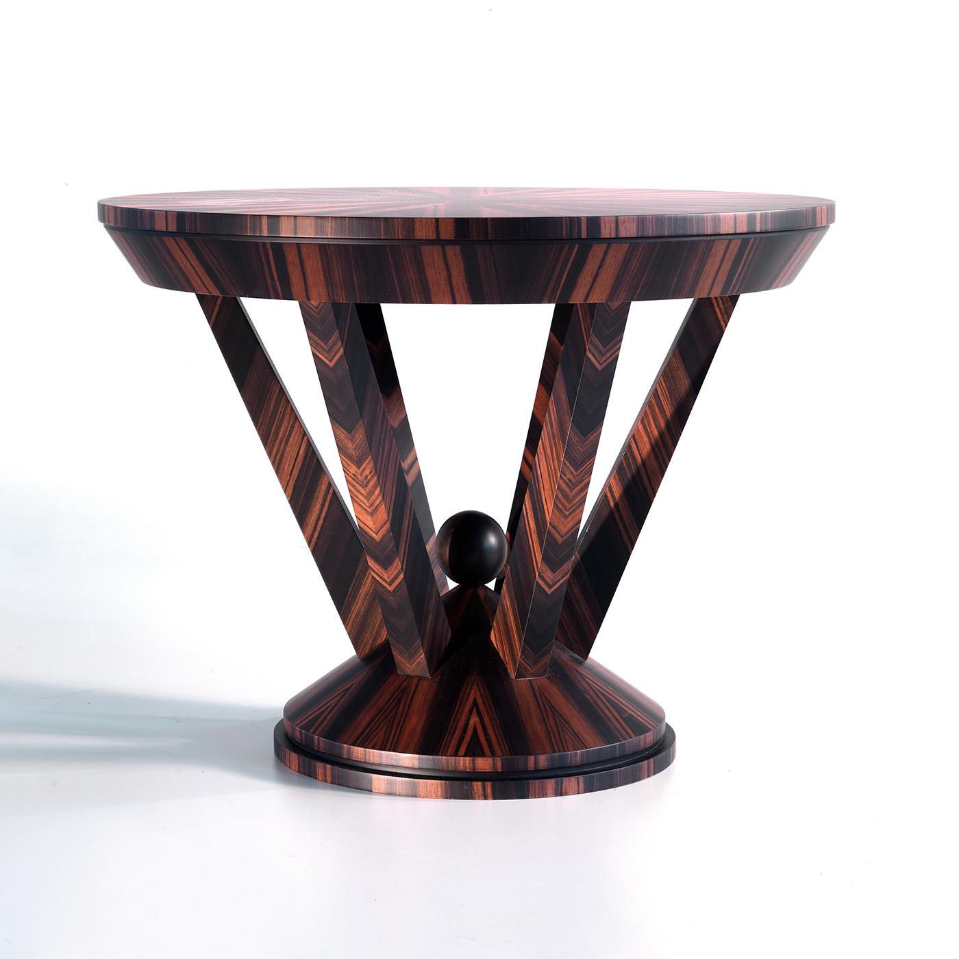 Cette table d'appoint ronde, d'un design saisissant et d'un impact visuel sophistiqué, présente une structure solide entièrement réalisée en ébène Makassar de grande qualité. Sa silhouette audacieuse se compose d'une base conique animée par un