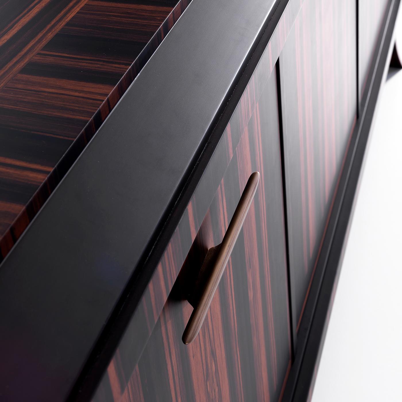 This stunning sideboard is way more than a mere storage space. The natural flair immediately conveyed by the Makassar ebony's veining offers a bewitching and faithful impression of the value of the structural material. Resting on four curved feet,