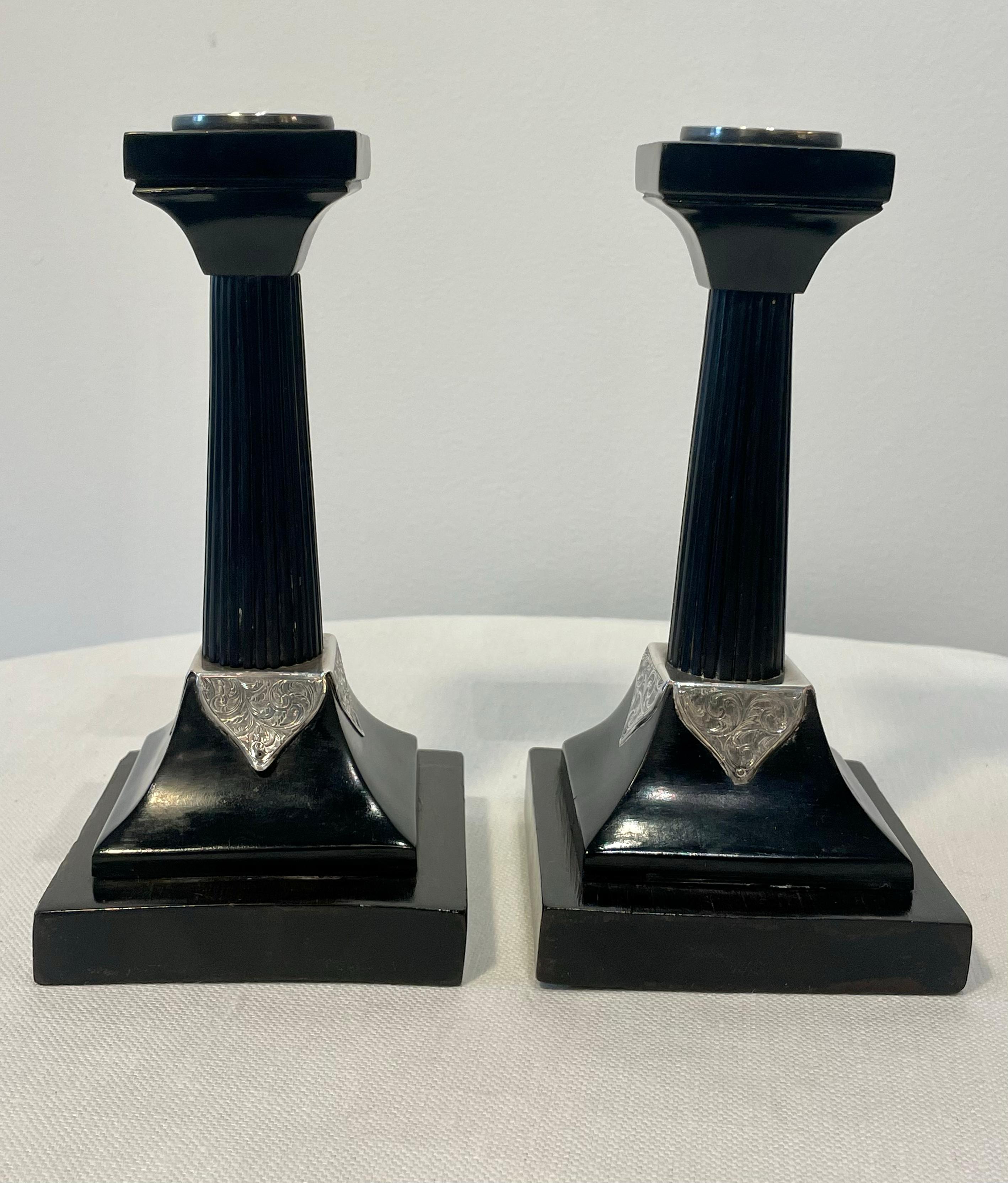 Pair of English silver-mounted arts and crafts ebony candlesticks. In classical revival taste with engraved and chased sterling silver detail. Circa 1915.  