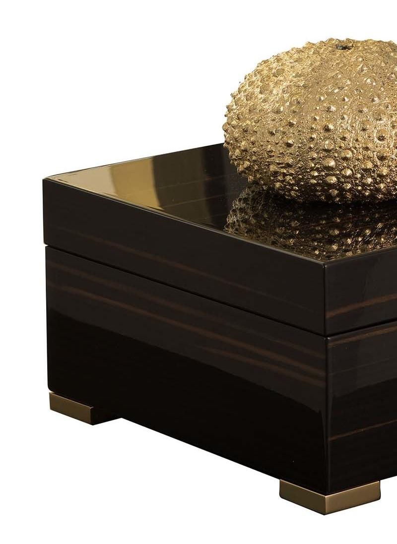 A refined accent in both modern and Classic decors, this box can be displayed in any room in the house as a purely decorative object or to store small trinkets. Combining a simple Silhouette with prized materials, the square frame of Macassar ebony