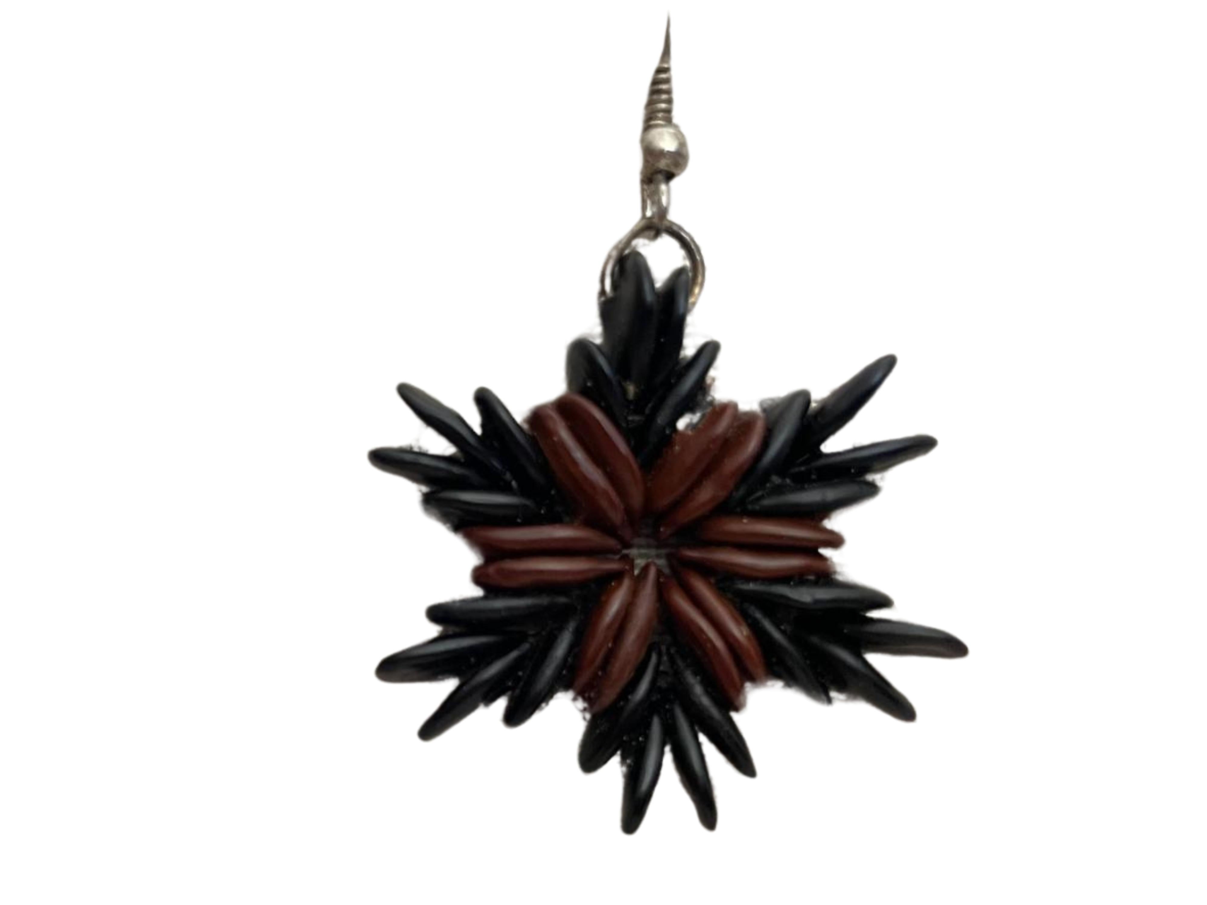 Introducing the Botanique Ebony Star Flares Earring —a masterpiece of heritage ware meticulously handcrafted from wild tamarind seeds. This intricately handmade earring has a double pair of black seeds at the end of the six points resembling flares