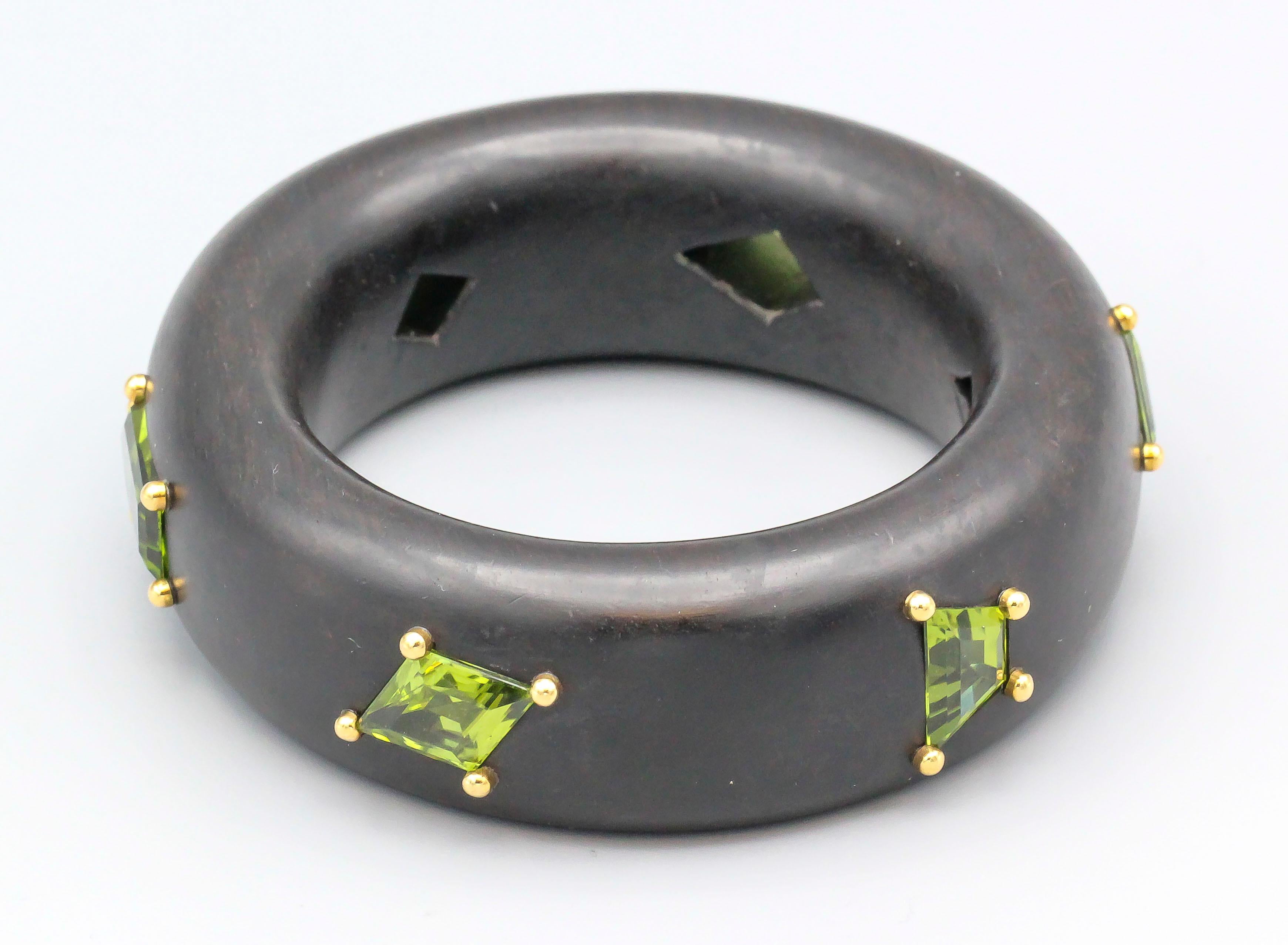 Fine bangle bracelet made in ebony wood and set with mixed cut peridots and 18k gold.  Medium size will fit a 6.5 inch wrist.