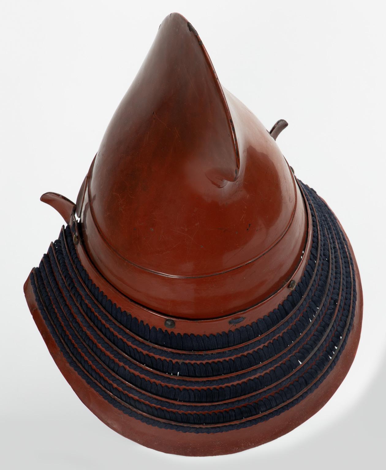 Iron finished in red lacquer
Edo period, 17th century

Among the kawari kabuto that reproduce shapes of headgears, the eboshi was a favorite by samurai since ancient times. In fact, helmets in the form of this court cap were very popular already