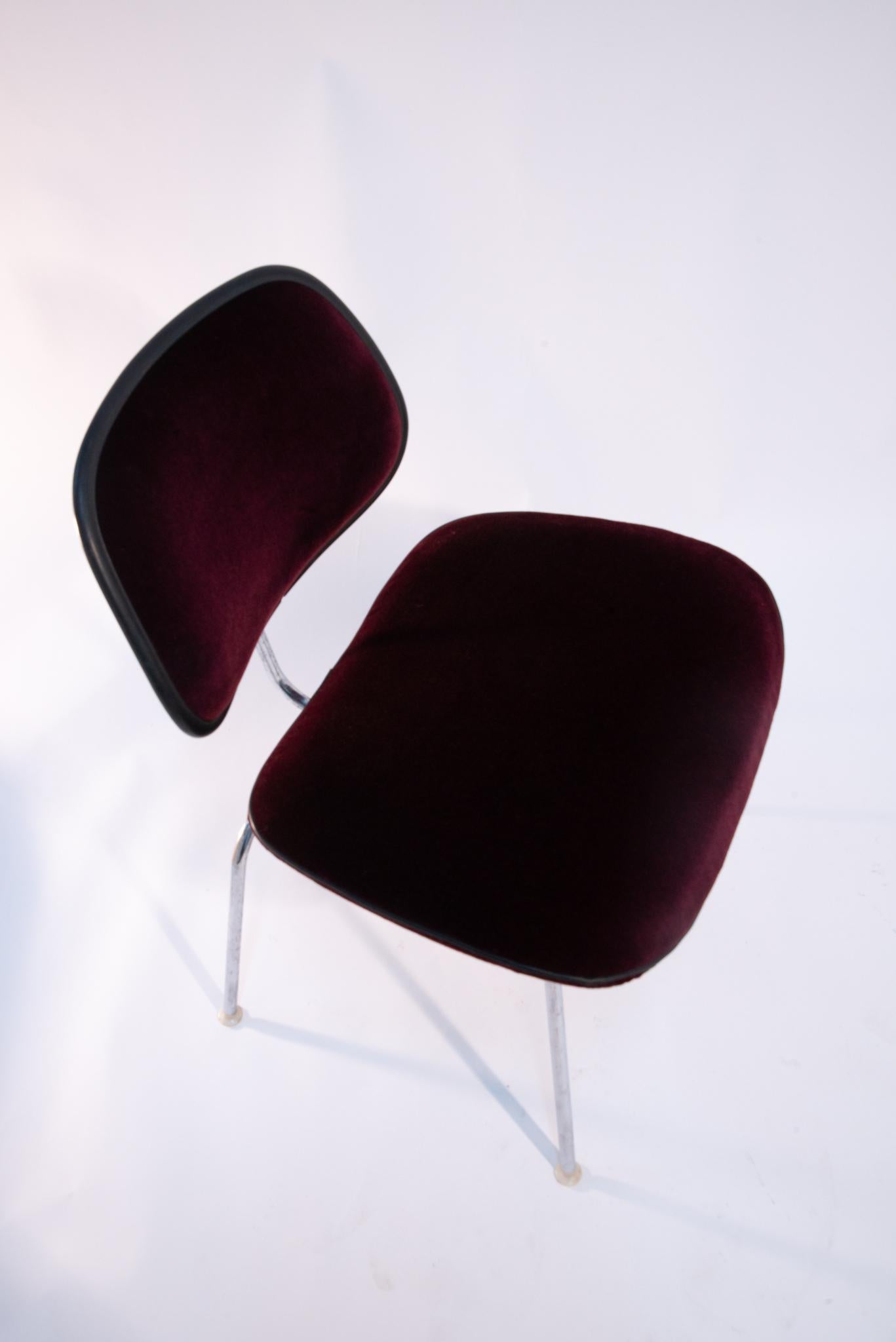 Ces chaises originales EC-127 padded DCM Chairs by Eames for Herman Miller ont été remises au goût du jour par un maître tapissier. Habillées d'un mohair bordeaux et finies par une trépointe en cuir noir, ces chaises de salle à manger emblématiques
