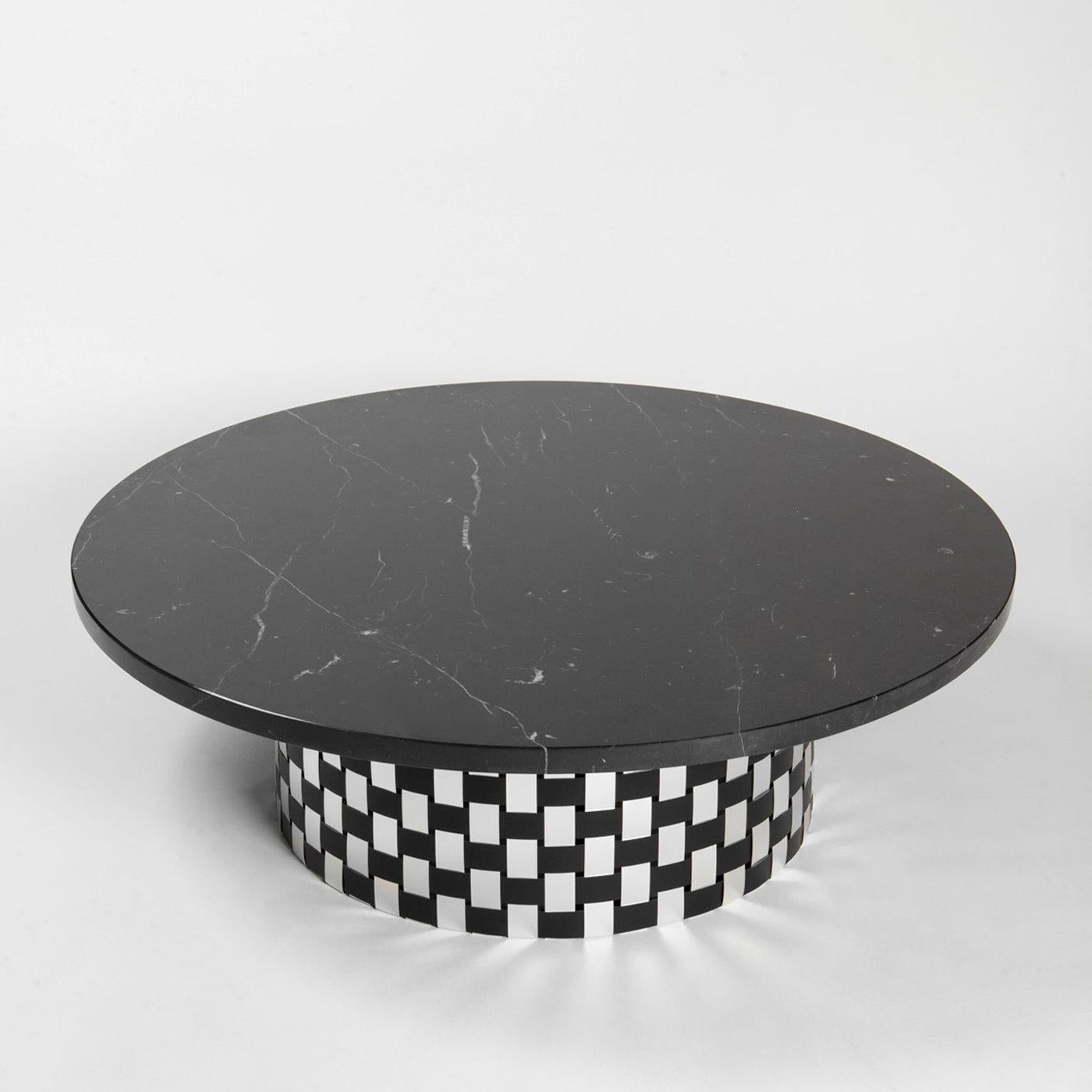 An impeccable balance of pure volumes and conflicting materials defines the design of this captivating coffee table named after the ancient Greek goddess of the waning moon. Featuring a thick and luxe round top in black Marquinia marble, the