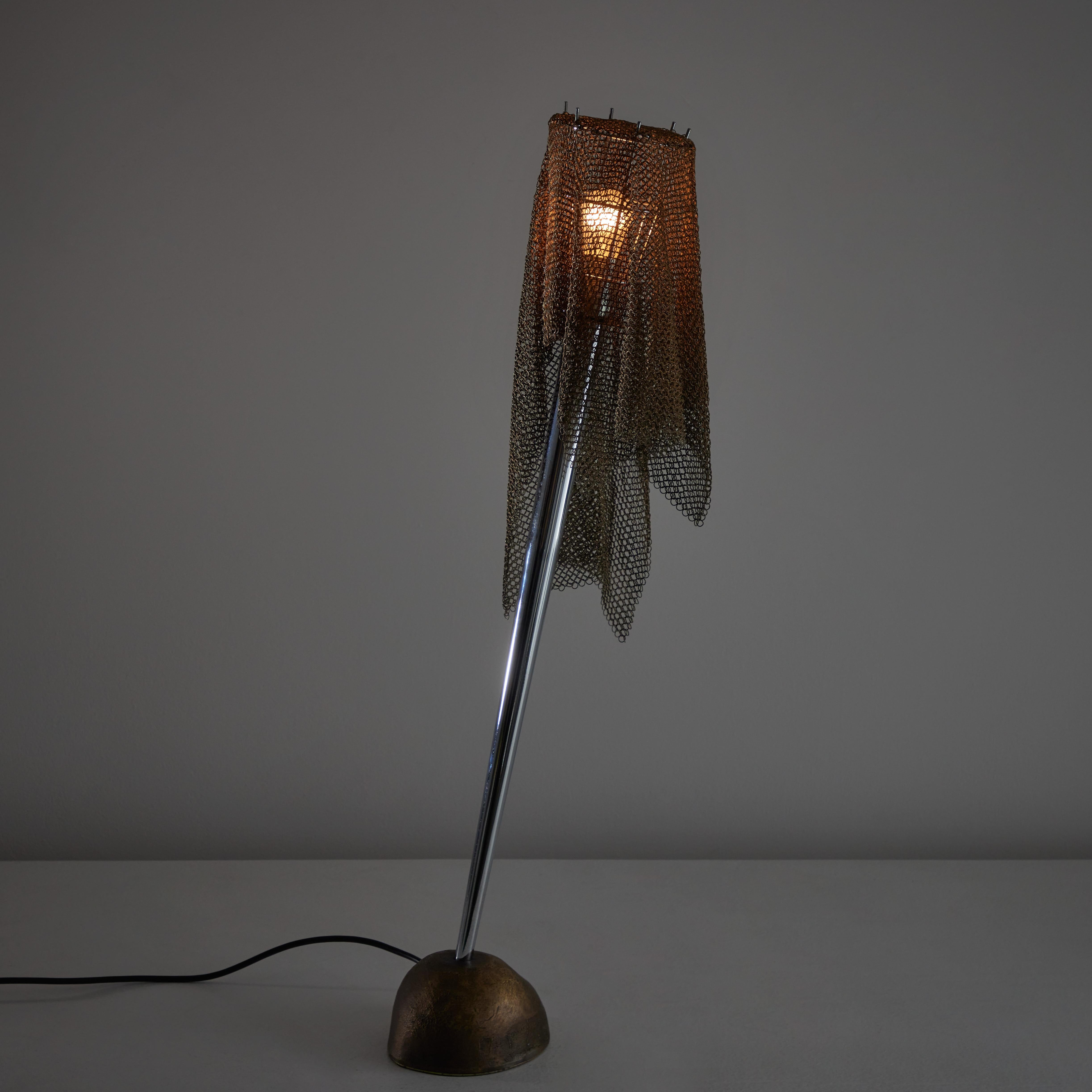 'Ecate' table lamp by Toni Cordero for Artemide. Designed and manufactured in Italy, circa 1990. A stone-like, cast-bronze base and conical stem with both brass and steel chain-mail shade. Stem and shade use a counter-balanced system when draped to