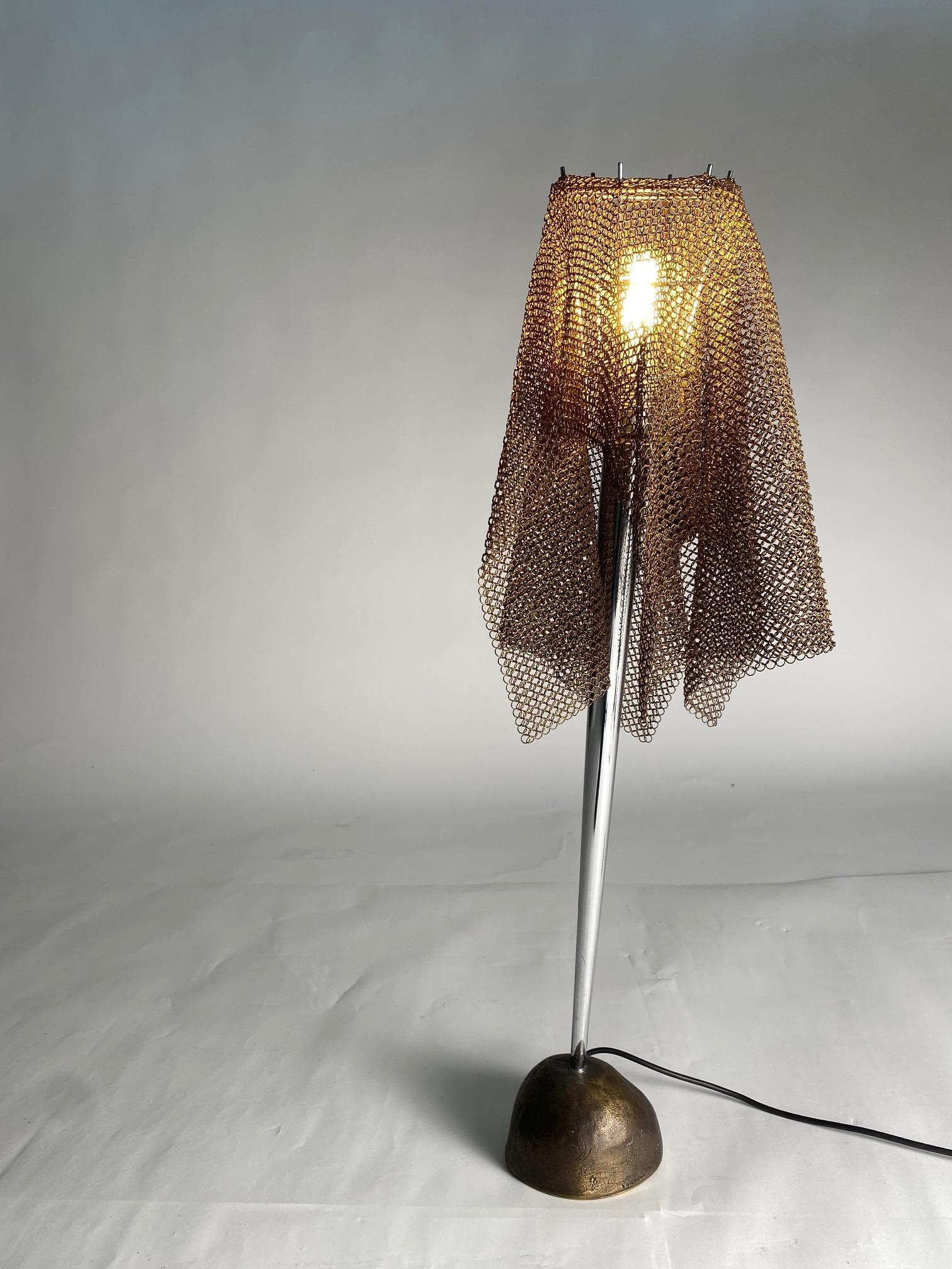 'Ecate' table lamp by Toni Cordero for Artemide.
 Designed and manufactured in Italy, circa 1990.
 A stone-like, cast-bronze base and conical stem with both brass and steel chain-mail shade. 