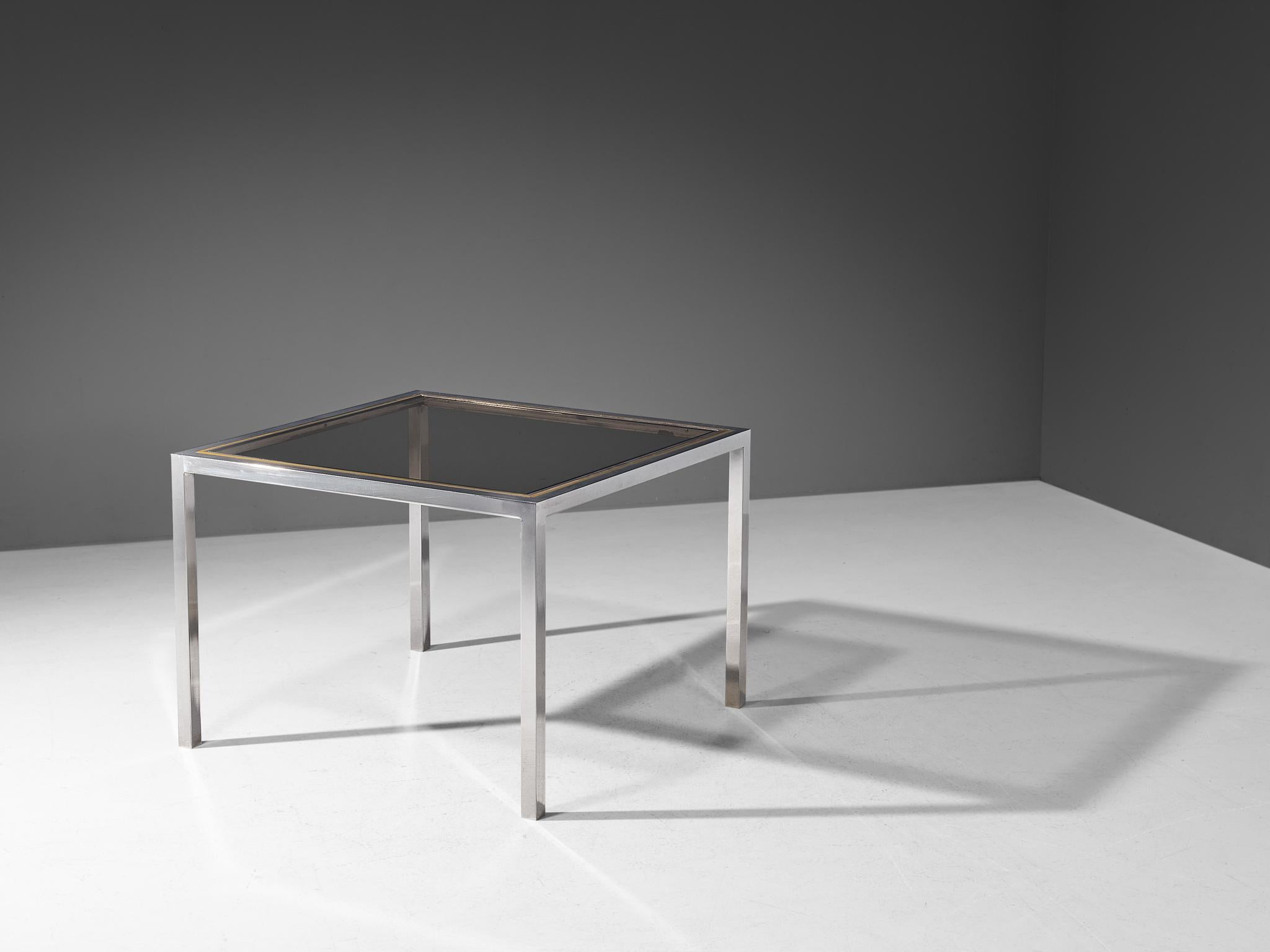 Dining table, brass, chromed steel, smoked glass, Italy, 1970s

This dining table features a geometric, clear-lined frame top in smoked glass and is surrounded by a brass border and further supported by a chromed steel base. The combination of these