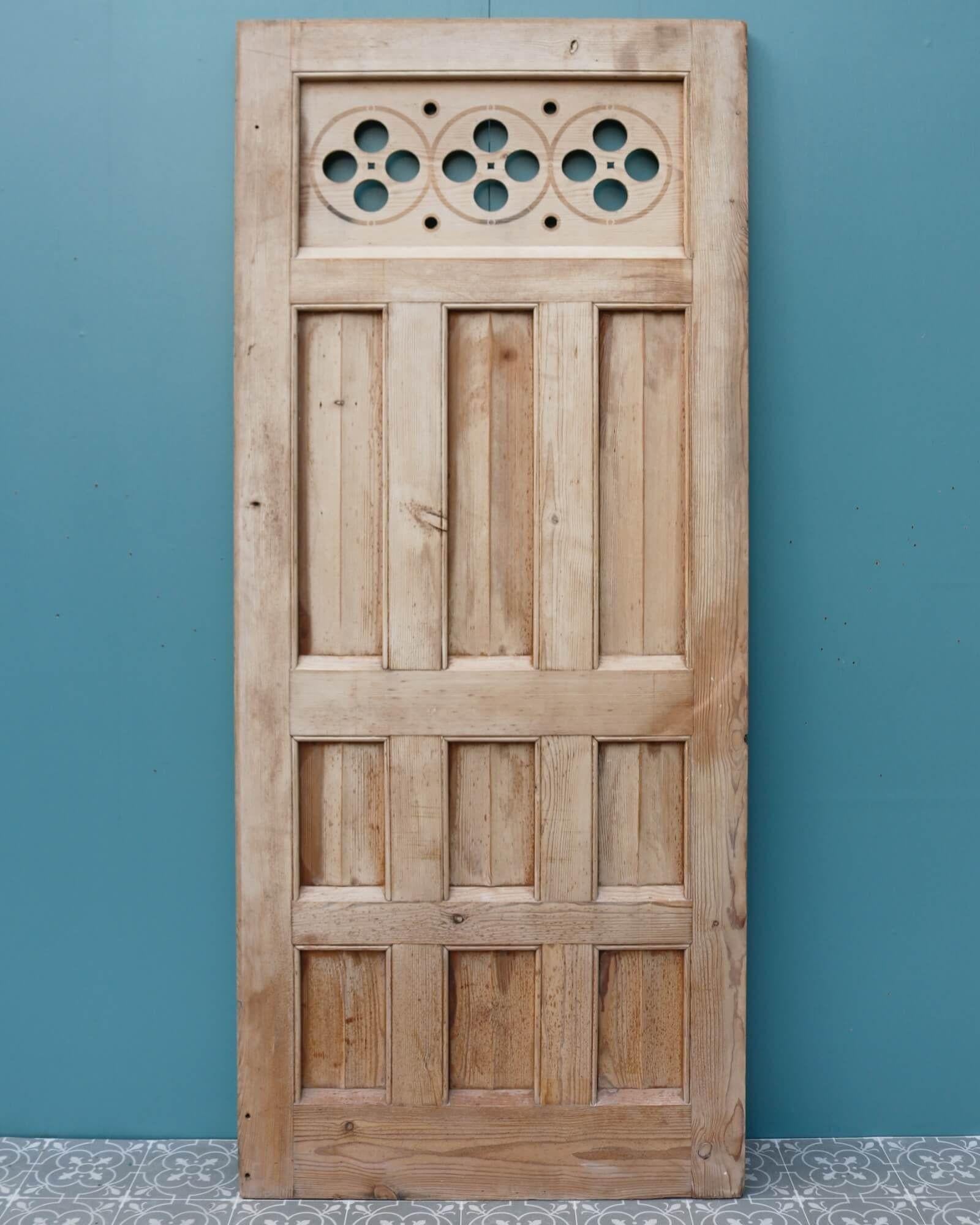 Sourced from an English church, this ecclesiastical style wall panel or door has an unusual design, making a stunning feature in any setting. It is crafted in pine with vertical paneling below a large horizontal panel decorated with circles and
