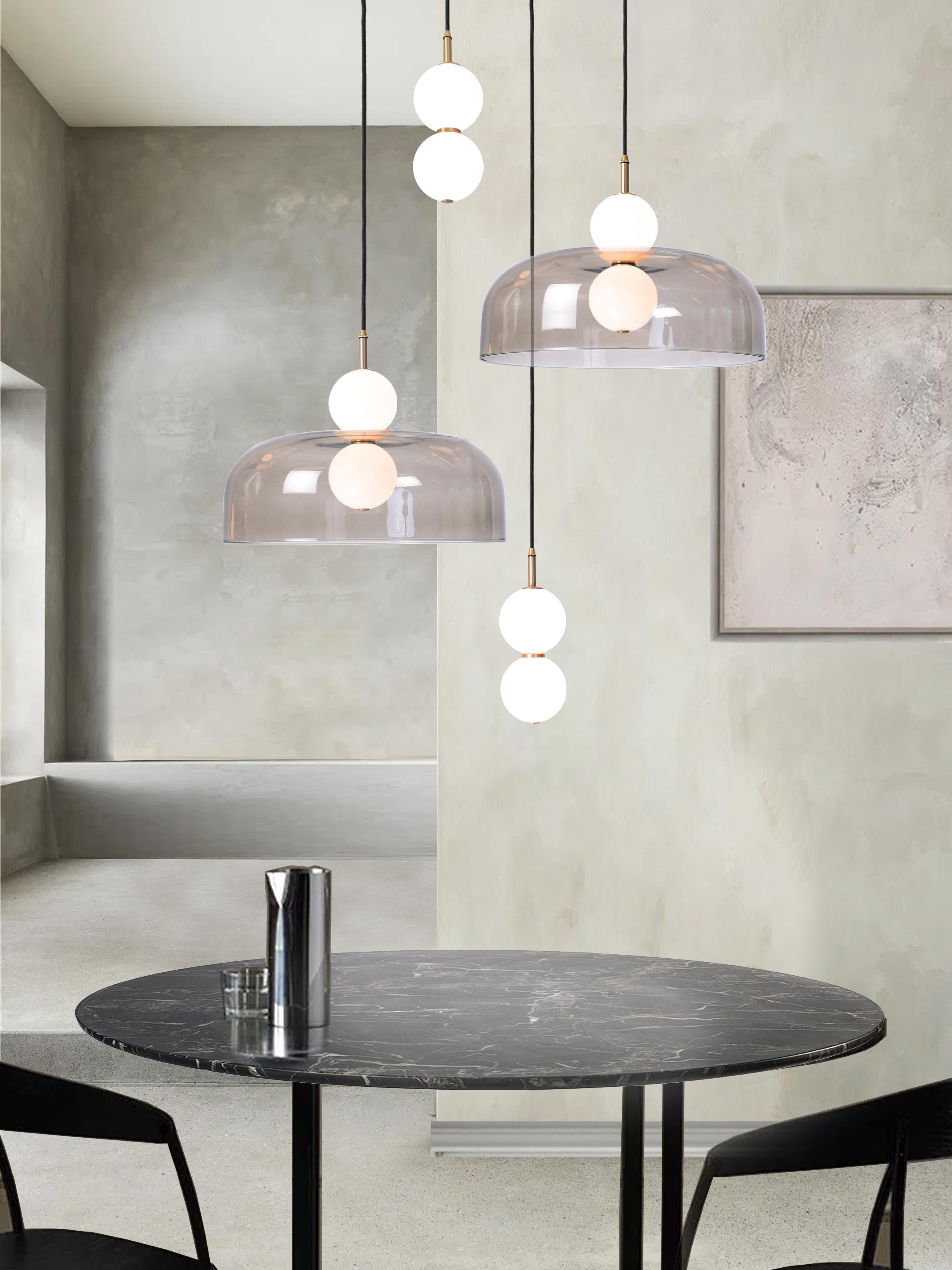 A hand spun shade suspended between white glass orbs, creating an echoed glow of light via the illusion of mirrored reflections.

Designed to be both functional and sculptural the Echo collection incorporates two pendant variations; lamp and