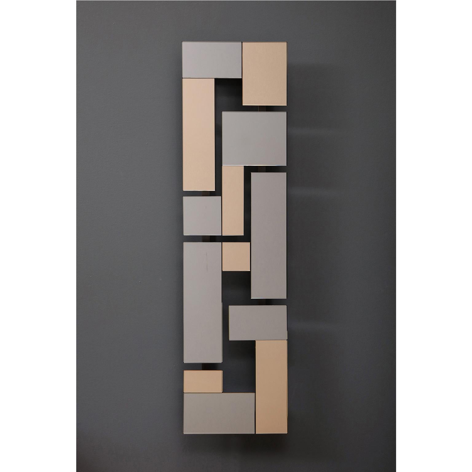 Contemporary, handcrafted, wall sconce in oxidized brass patina base with a façade consisting of rectangular pieces of colored mirrors in geometric formations. LED strip light source on the back side of the sconce


Materials: Brass patina,