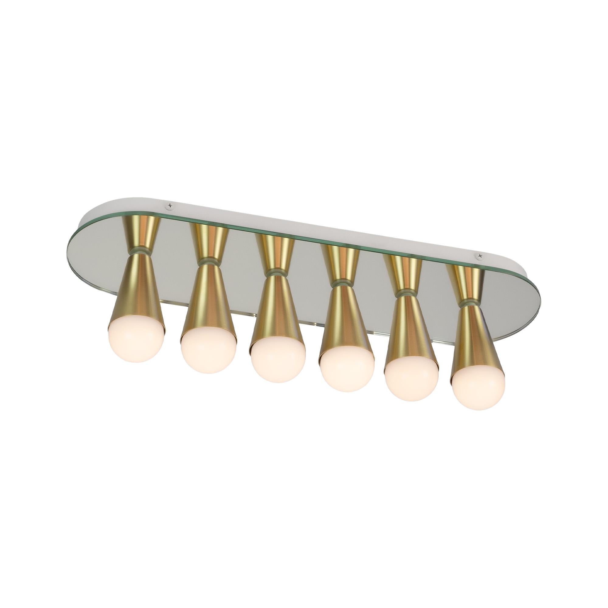 Sencilla, elegante y juguetona, la serie Echo es una línea de luminarias de montaje en superficie que pueden utilizarse en la pared o en el techo. Los conos blancos o de latón se montan en cristal espejado para reflejar perfectamente cada bombilla,
