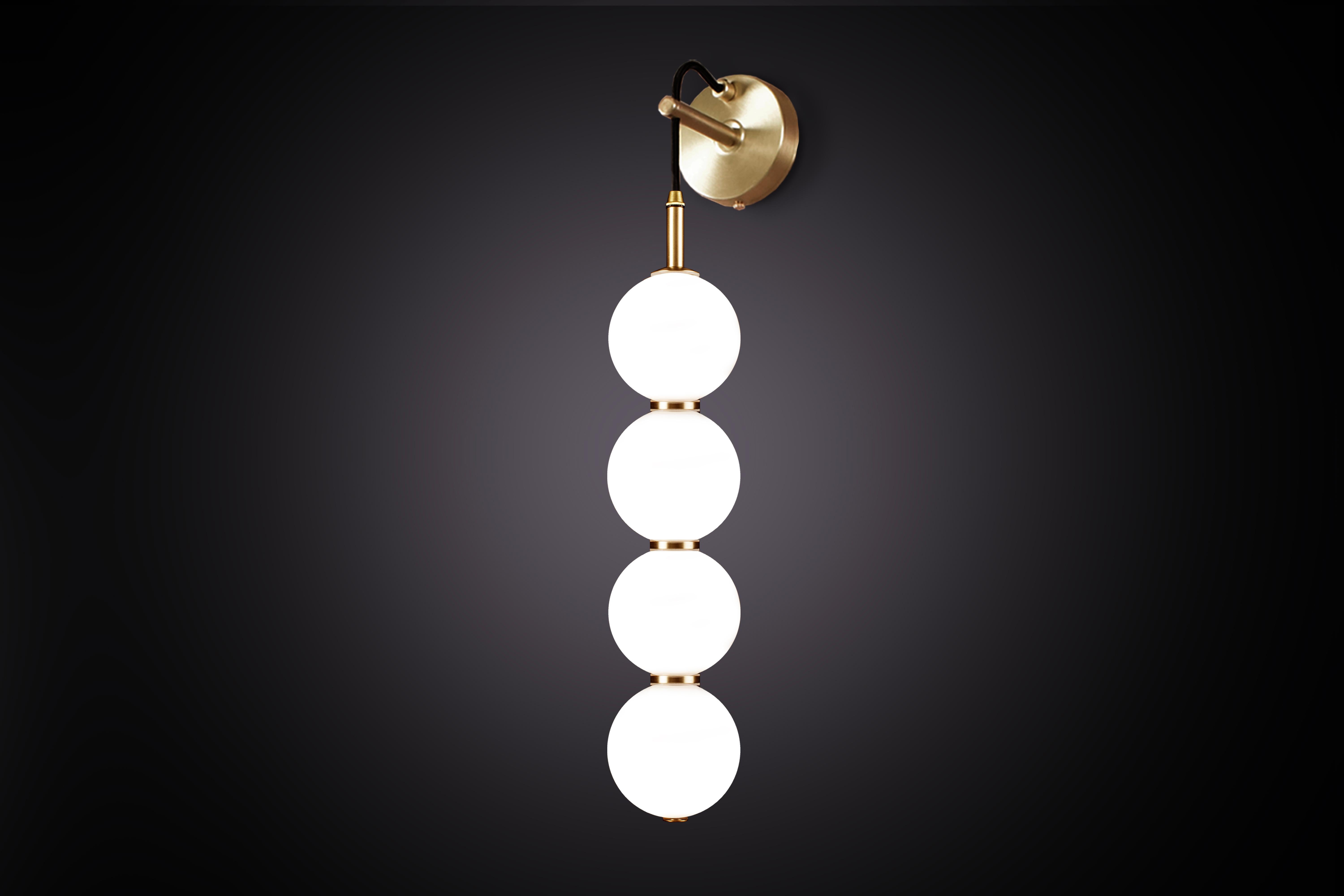 Delicate white opaline glass orbs stacked on top of one another to create an echoed glow of light and the illusion of subtle reflections.