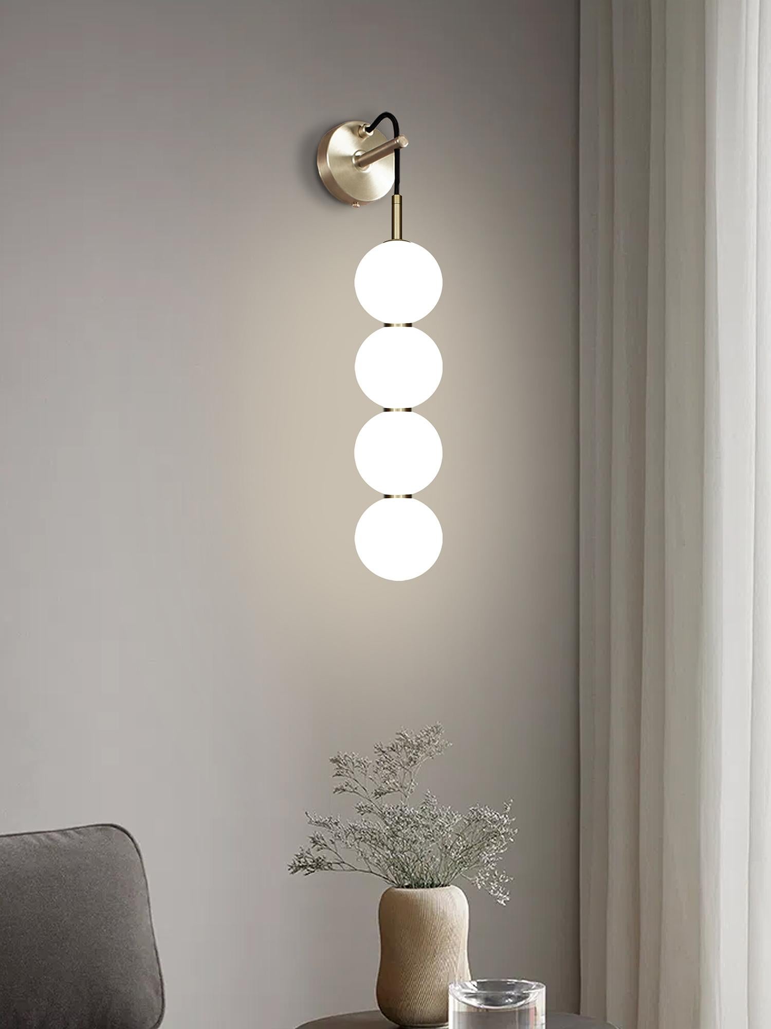 Delicate white opaline glass orbs stacked on top of one another to create an echoed glow of light and the illusion of subtle reflections.