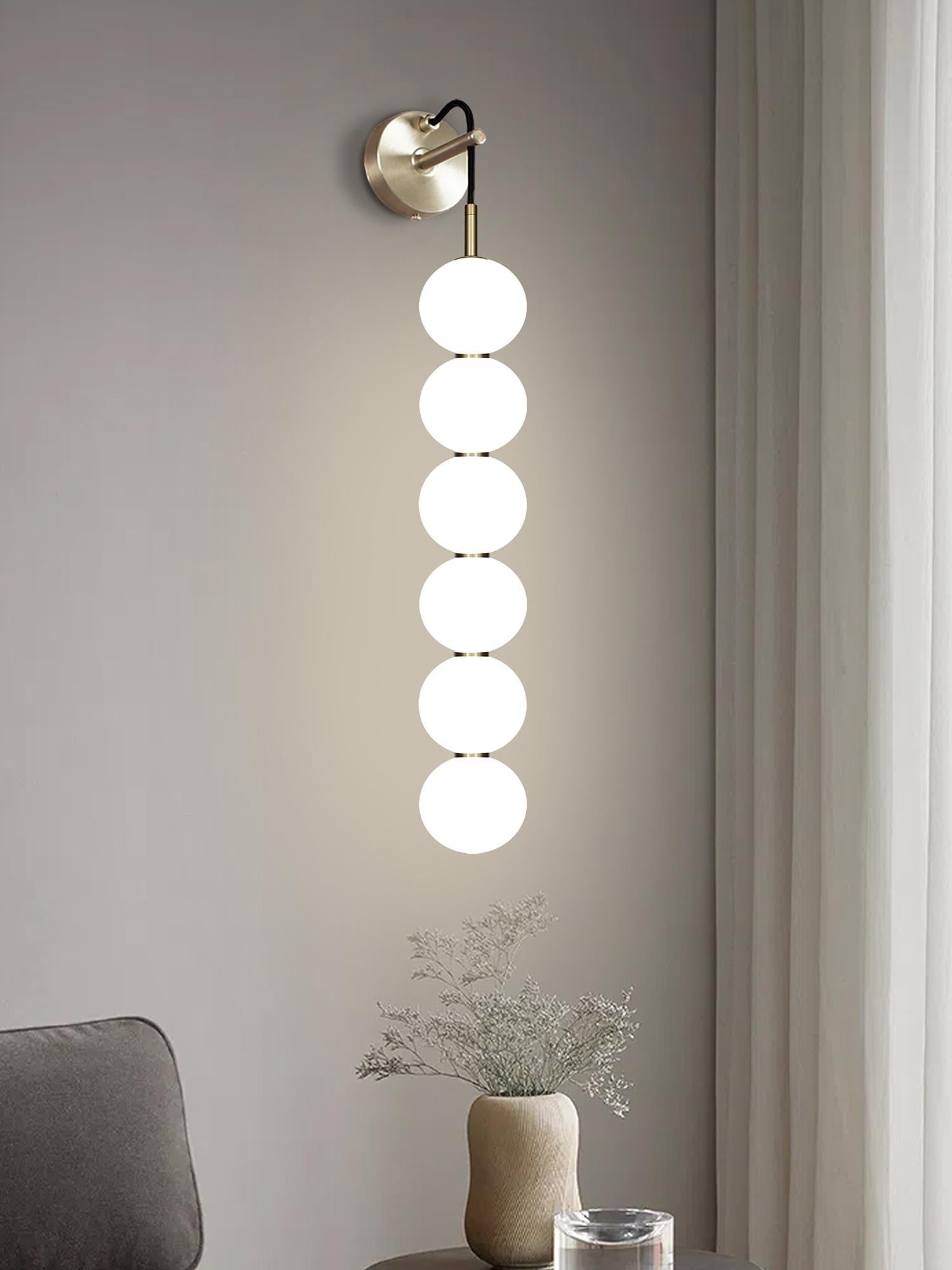 Delicate white opaline glass orbs stacked on top of one another to create an echoed glow of light and the illusion of subtle reflections.