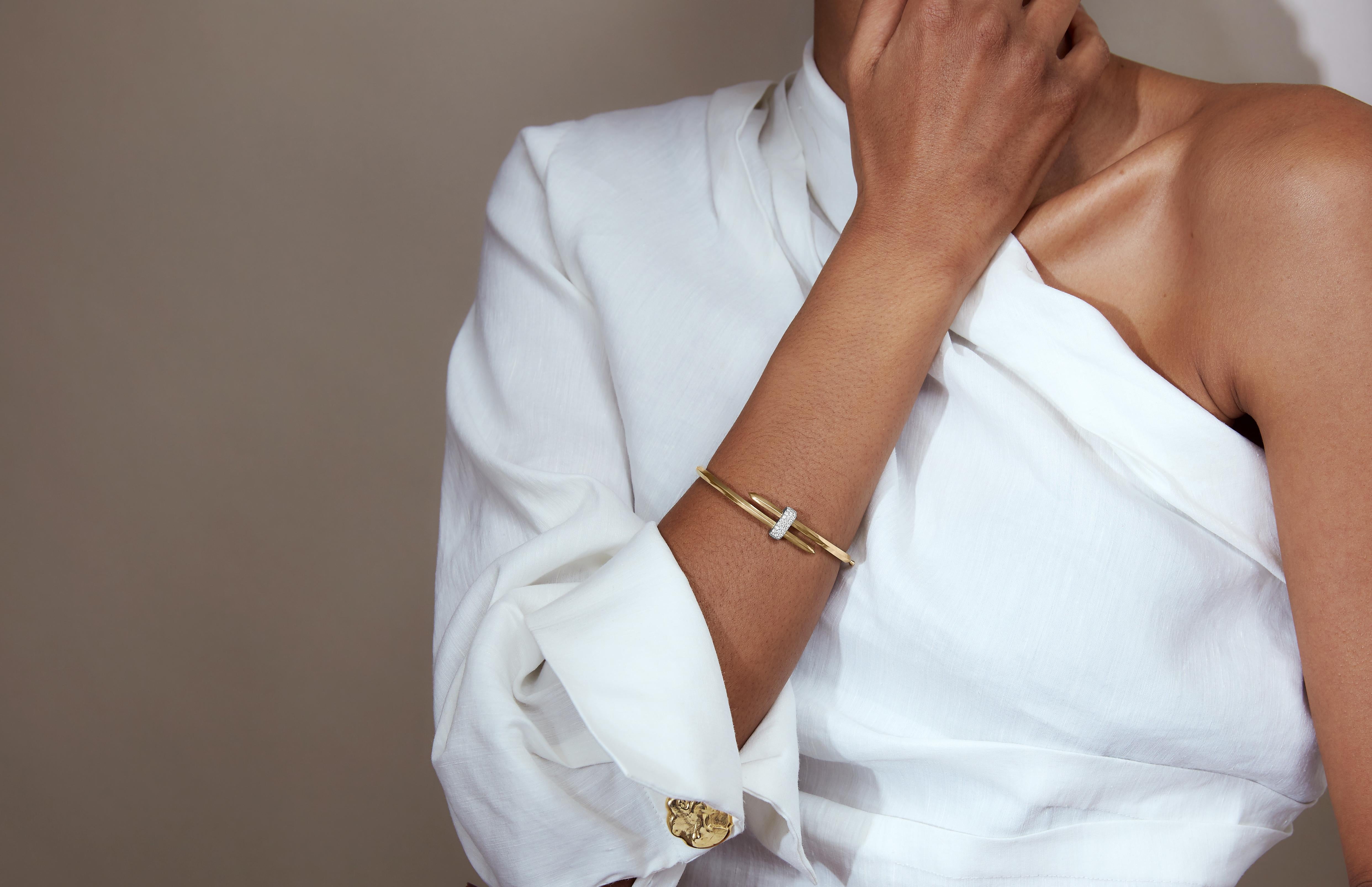 Nehmen Sie die Herausforderung an. Dieses Ecksand Duel Diamantarmband ist von der Kunst des Fechtens inspiriert. Das Gelbgoldband ist den Kanten des Degens nachempfunden und windet sich spiralförmig um das Handgelenk. Das gedrehte Band ist mit einem