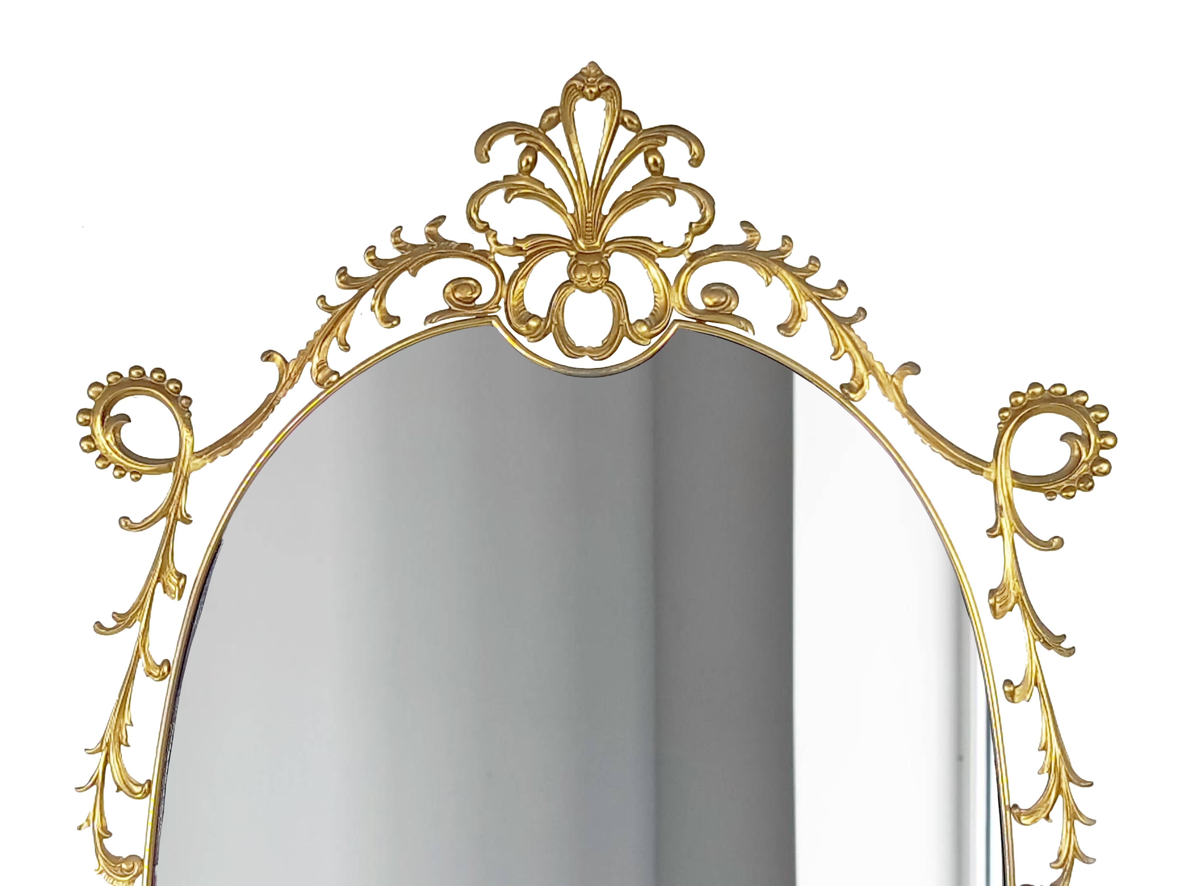 This Italian wall mirror was made from a brass frame with a mirrored and colored blue glass in decorative Art Nouveau, Rocaille style. It remains in very good condition: oxidation spots consistent with age.