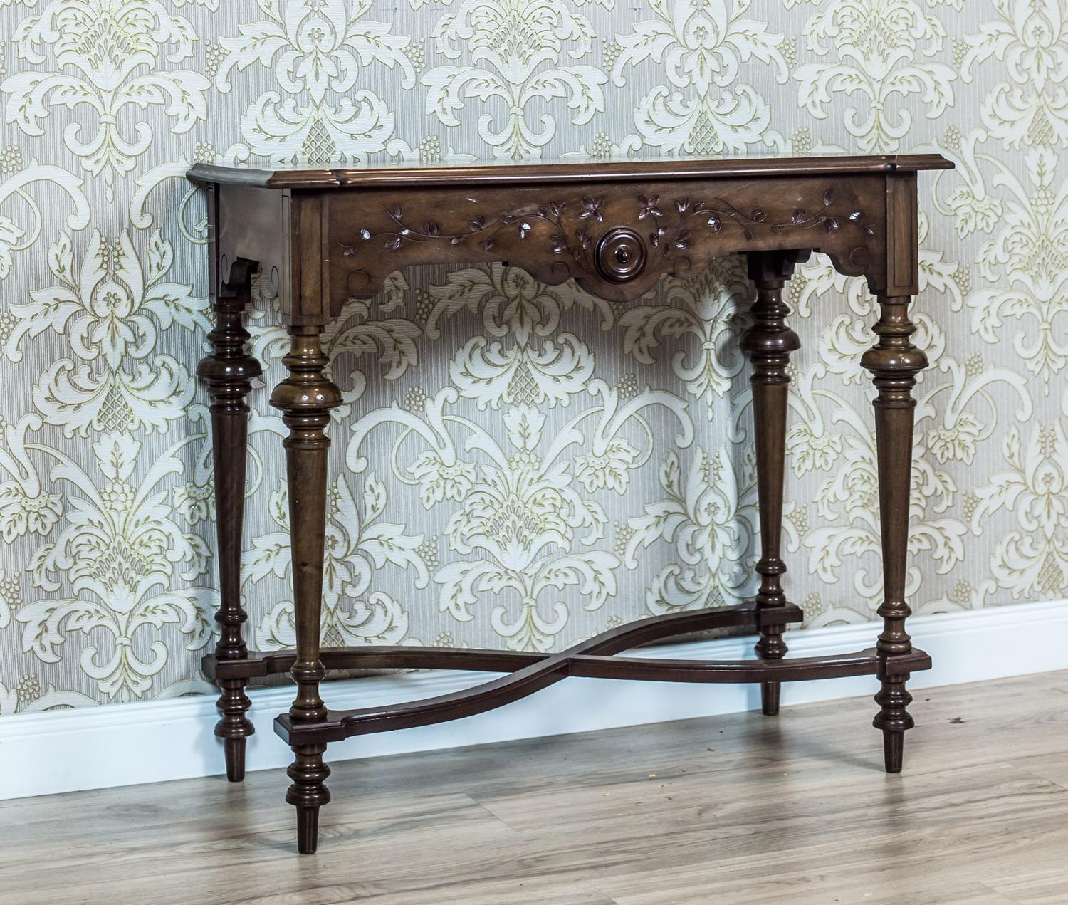 We present you this narrow wall table in the console type, circa Q3 of the 19th century.
The table is placed on turned legs, which are connected with stretchers in the form of an hourglass.
The line of the apron is wavy. From the front, it is