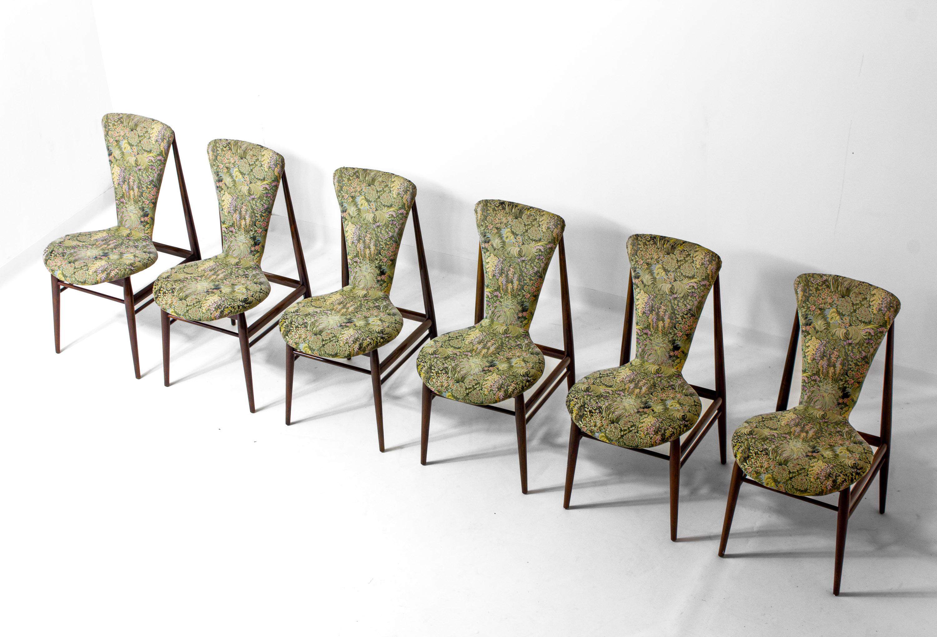 Set of six Scandinavian dining chairs from the 1960s featuring solid teak frames and floral upholstery. Each chair has a tapered frame with slightly angled back legs and a distinctive curved backrest that flows seamlessly into the seat. The floral