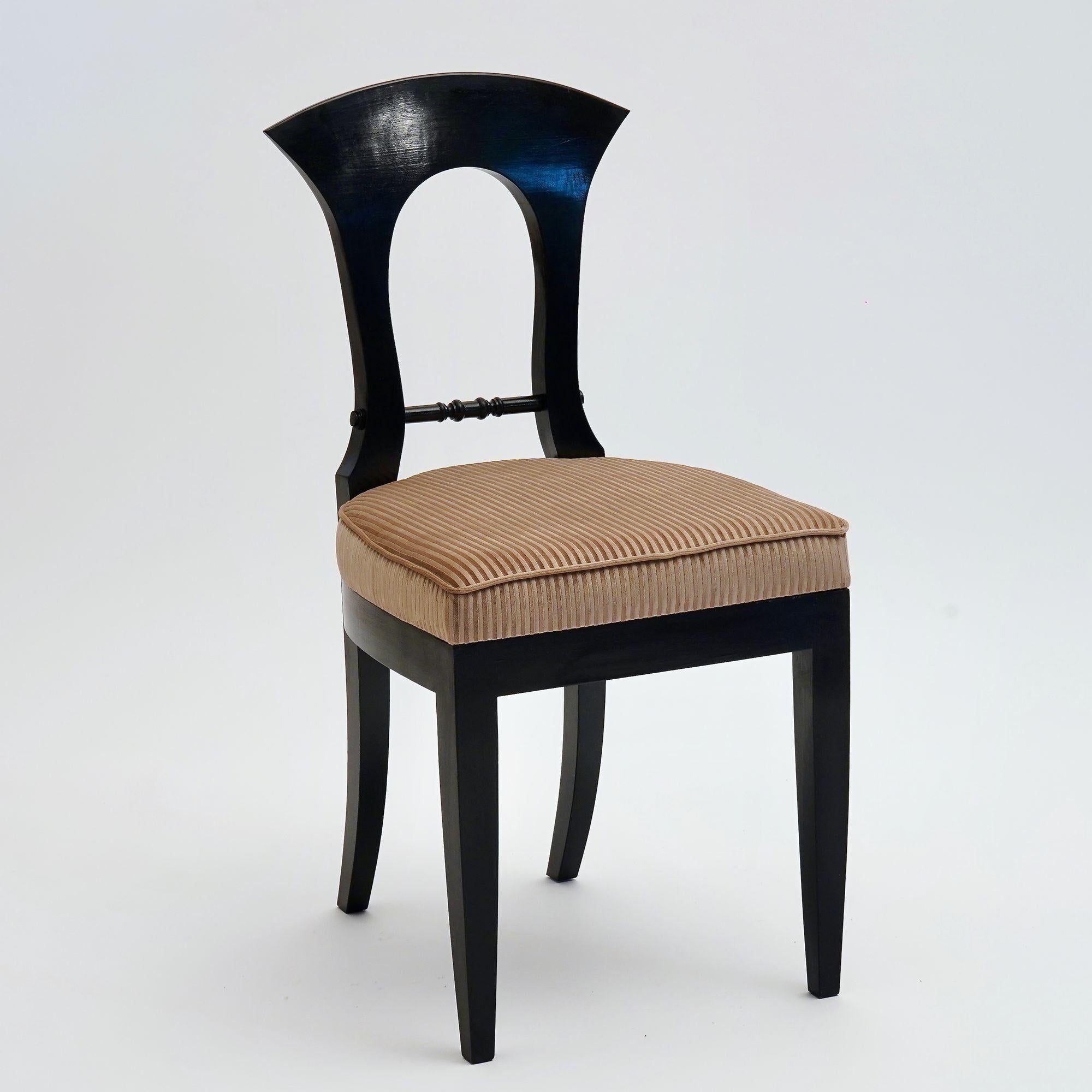 This Heinrich-August dining chair is from our Eclectica collection.
It is crafted from solid Italian walnut wood with an ebonized finish. This finish is applied by hand with shellac for a smooth, glossy feel.
The seat is padded for comfort and