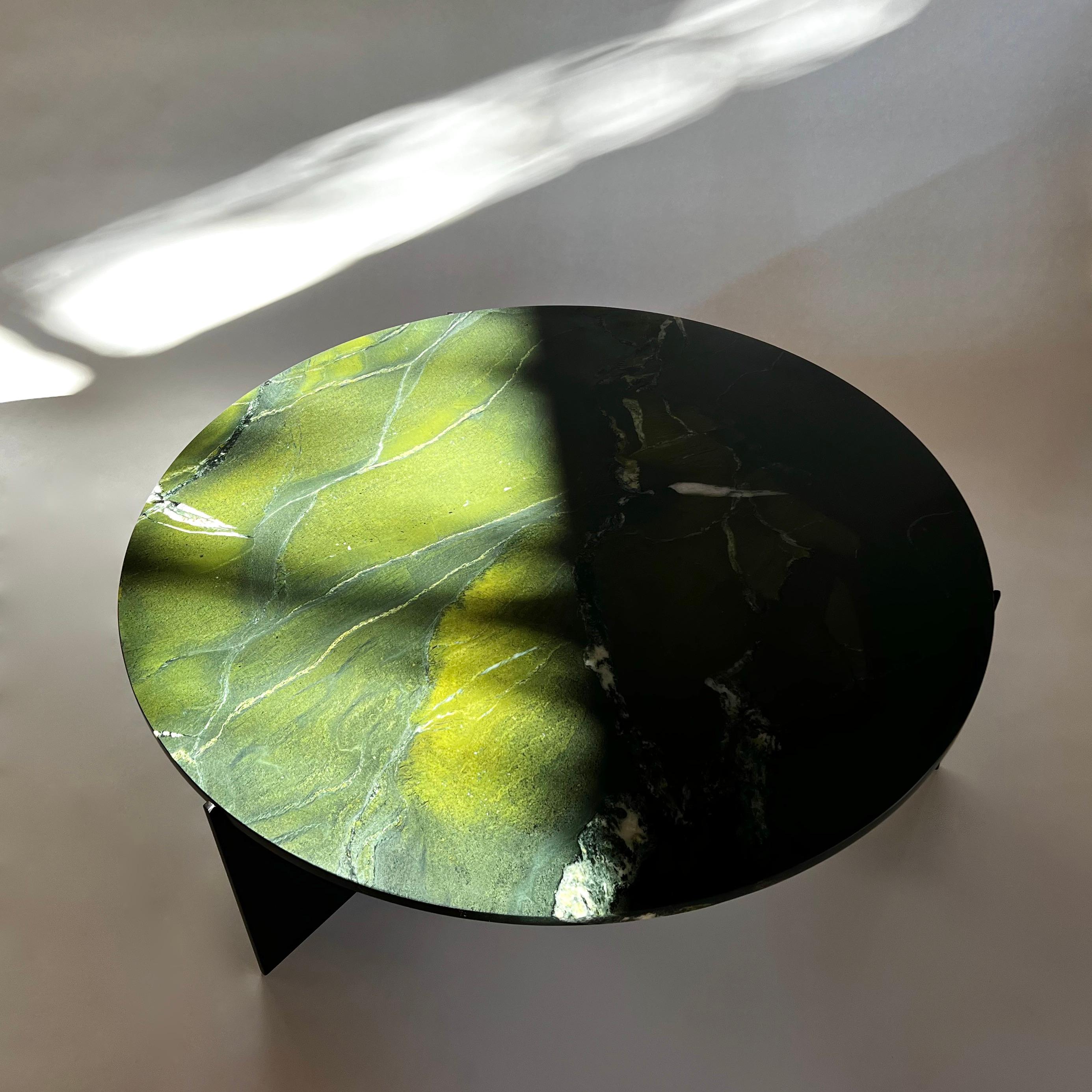 Ten10 Eclipse Couchtisch mit einem Gestell aus Edelstahl, pulverbeschichtet in mattem Schwarz, und einer runden, geschliffenen Granitplatte mit einem Durchmesser von 43 3/8
