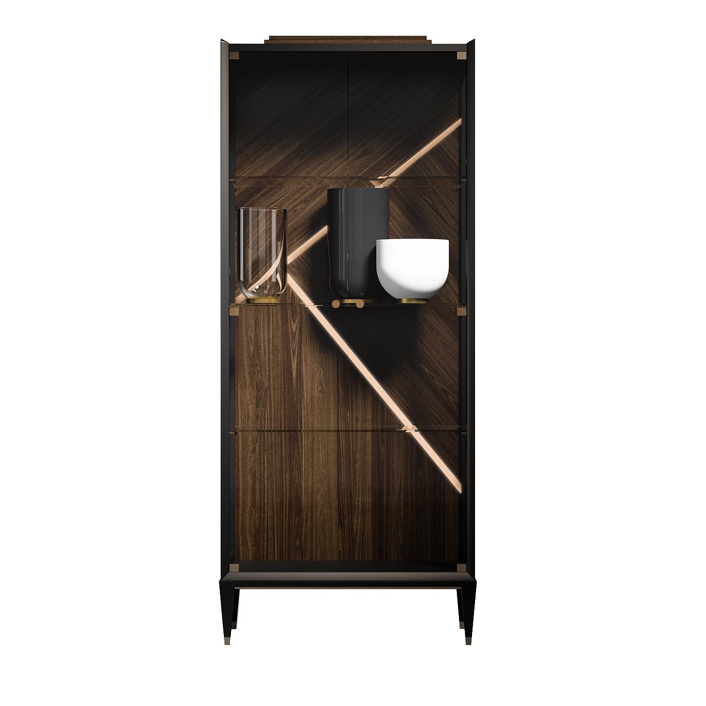 This sleek structure of mixed materials has a wooden frame with a velvet-like, black finish supported by four tapered feet with metal ferules. Both side and front panels are made of glass, with double doors that hinge open on a striking back panel