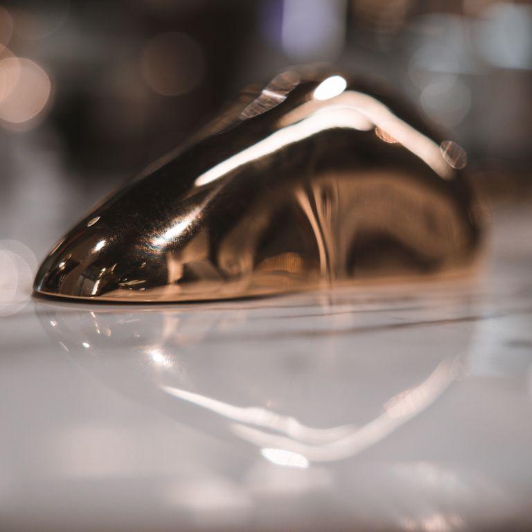 Ti presentiamo The Eclipse, una splendida scultura in ottone progettata per elevare l'arredamento della tua casa con la sua estetica elegante e raffinata. A forma di ciottolo liscio, Eclipse si ispira alla bellezza senza tempo delle pietre di fiume,