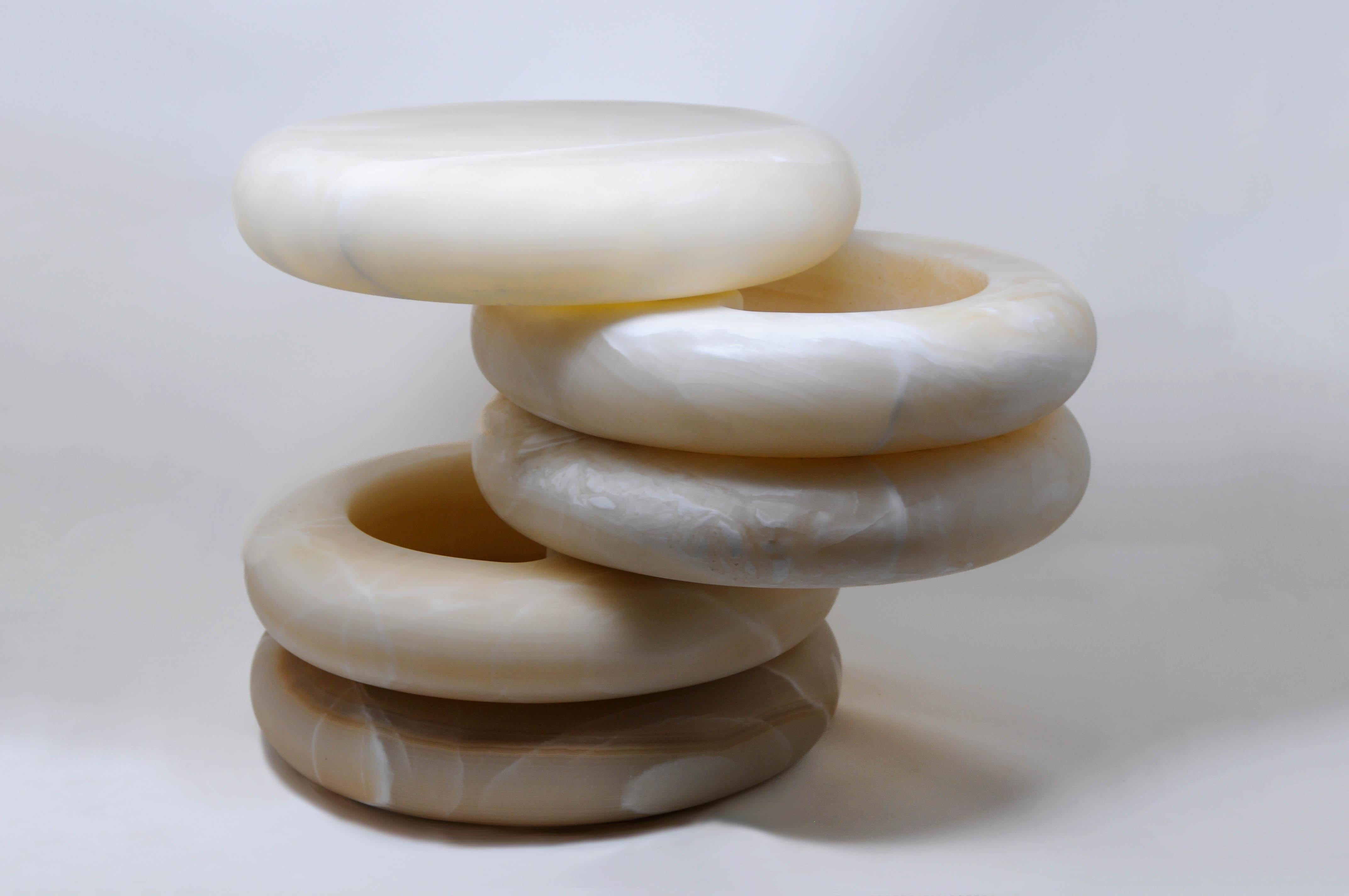 Rings of white onyx tower in a light gradient descent to create Olo Eclipse Nightstand. This iteration of our beloved nightstand hides two secret compartments which are revealed with the rotation of it’s central rings. This movement seeks to
