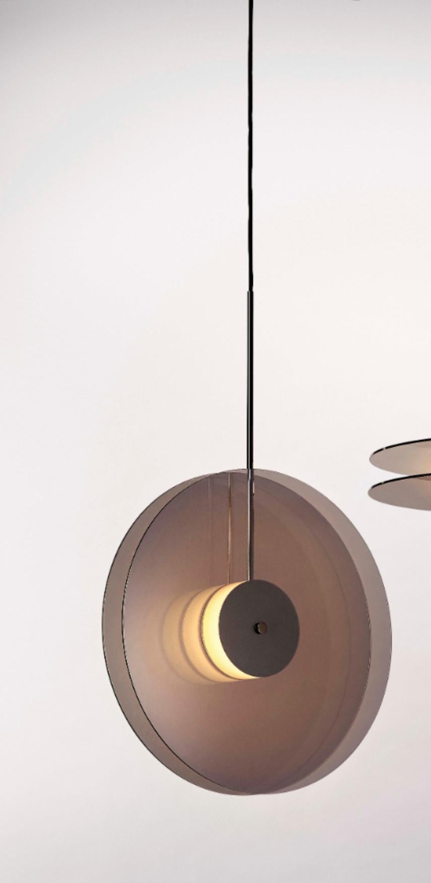 Eclipse pendant light by Dechem Studio
Dimensions: D 50 x H 200 cm
Materials: brass, glass.

Inspired by the 1930s modernist design and Art Deco, Eclipse lamp is comprised of two metallized glass discs with a source of soft light behind the