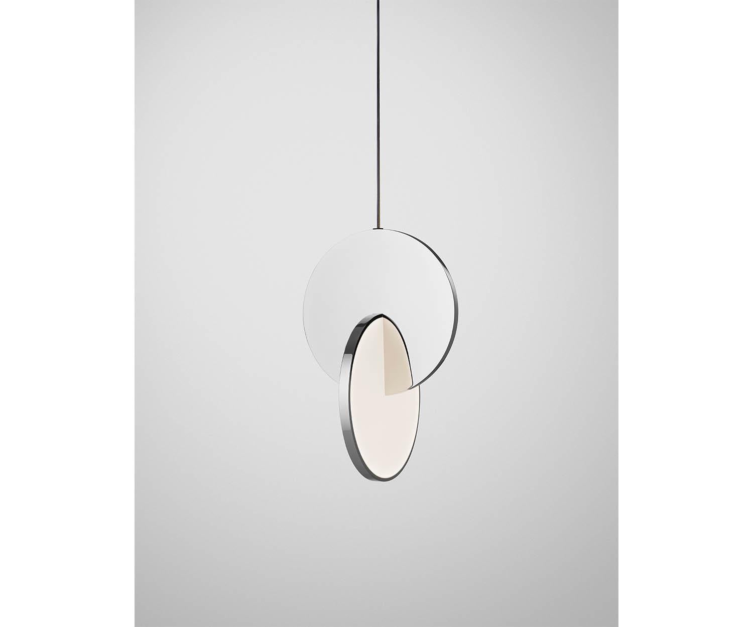 Eclipse pendant is celestial in both its name and inspiration. Mirror-polished chrome and acrylic discs interact, dissect and obscure, which both eclipses and reveals its illumination to the viewer at the same time. Eclipse has been produced as a