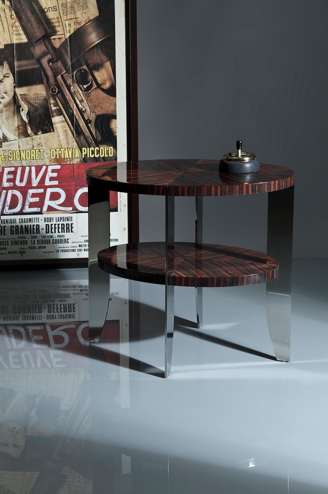 A more slender version of the Eclipse coffee table, but with the same steel/wood trademark junction detail.
Top and shelf in natural macassar 100% gloss
Legs in polished stainless steel.

