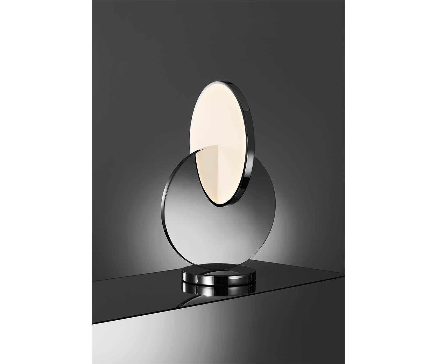 Eclipse table lamp has a sculptural silhouette with a mobile-like quality that changes at every angle. Chrome and acrylic discs supported by a mirror- polished base rotate by ninety degrees to angle the diffusion of light and reveal multiple