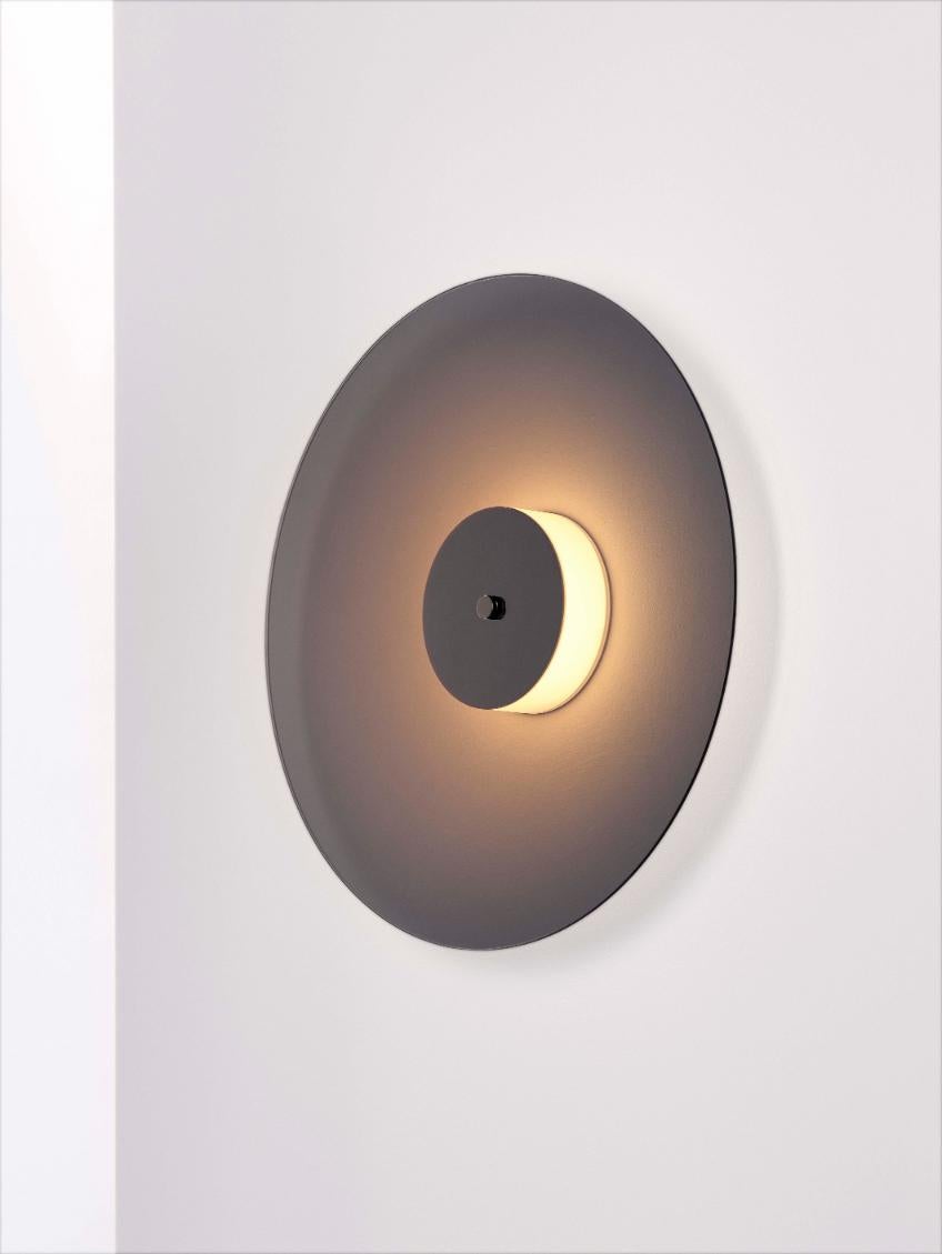 Eclipse wall light by Dechem Studio
Dimensions: D 40 x H 10 cm
Materials: Brass, glass.

Inspired by the 1930s modernist design and Art Deco, Eclipse lamp is comprised of two metallized glass discs with a source of soft light behind the shiny