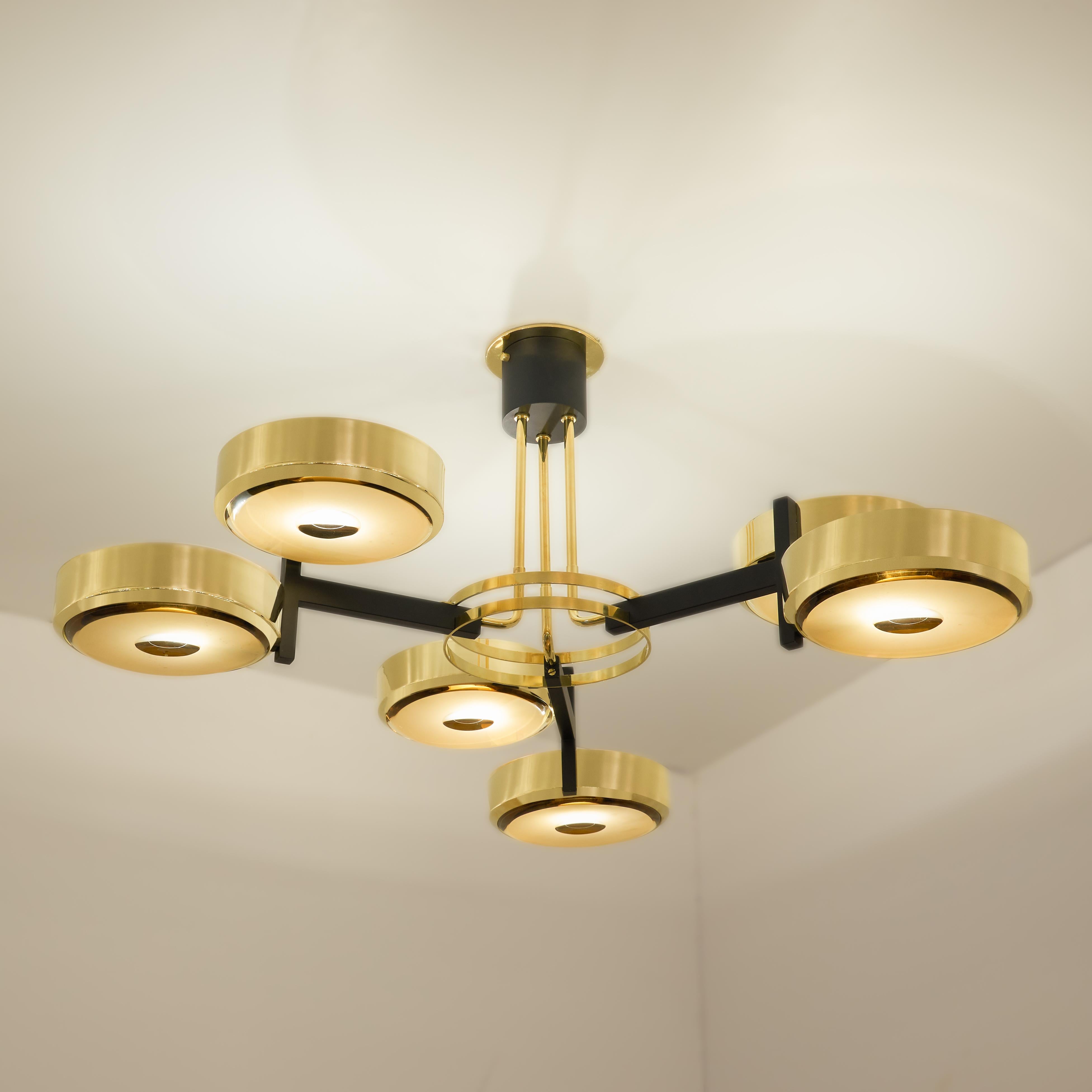 The Eclissi ceiling light is designed around three pairs of eclipsing shades bound by a series of brass rings and a distinctive triple stem. Shown in polished brass with black accents and fitted with our Ambra Carved Glass.

Customization Options: