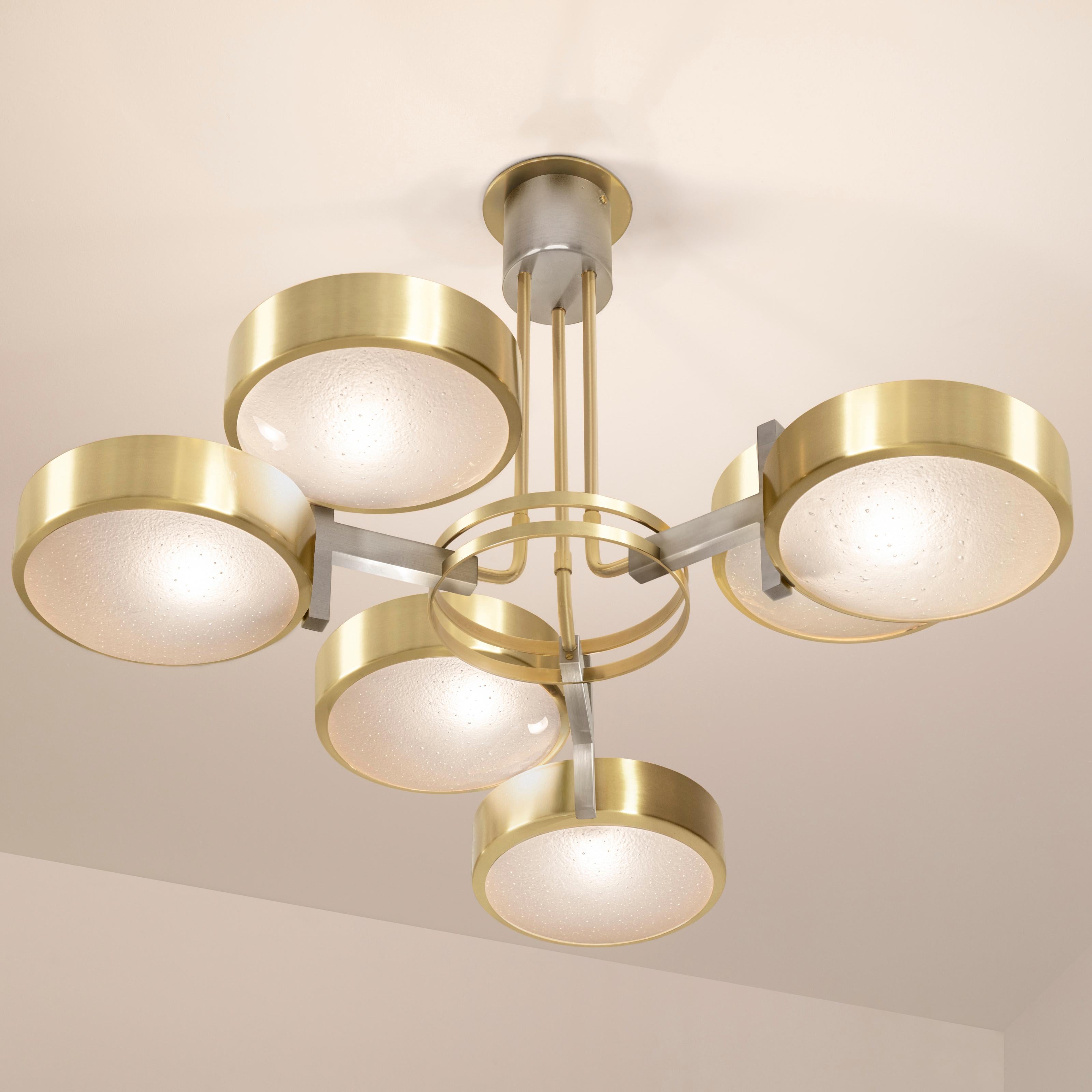 The Eclissi ceiling light is designed around three pairs of eclipsing shades bound by a series of brass rings and a distinctive triple stem. The first images show the fixture in our satin brass finish with satin brass accents-subsequent pictures
