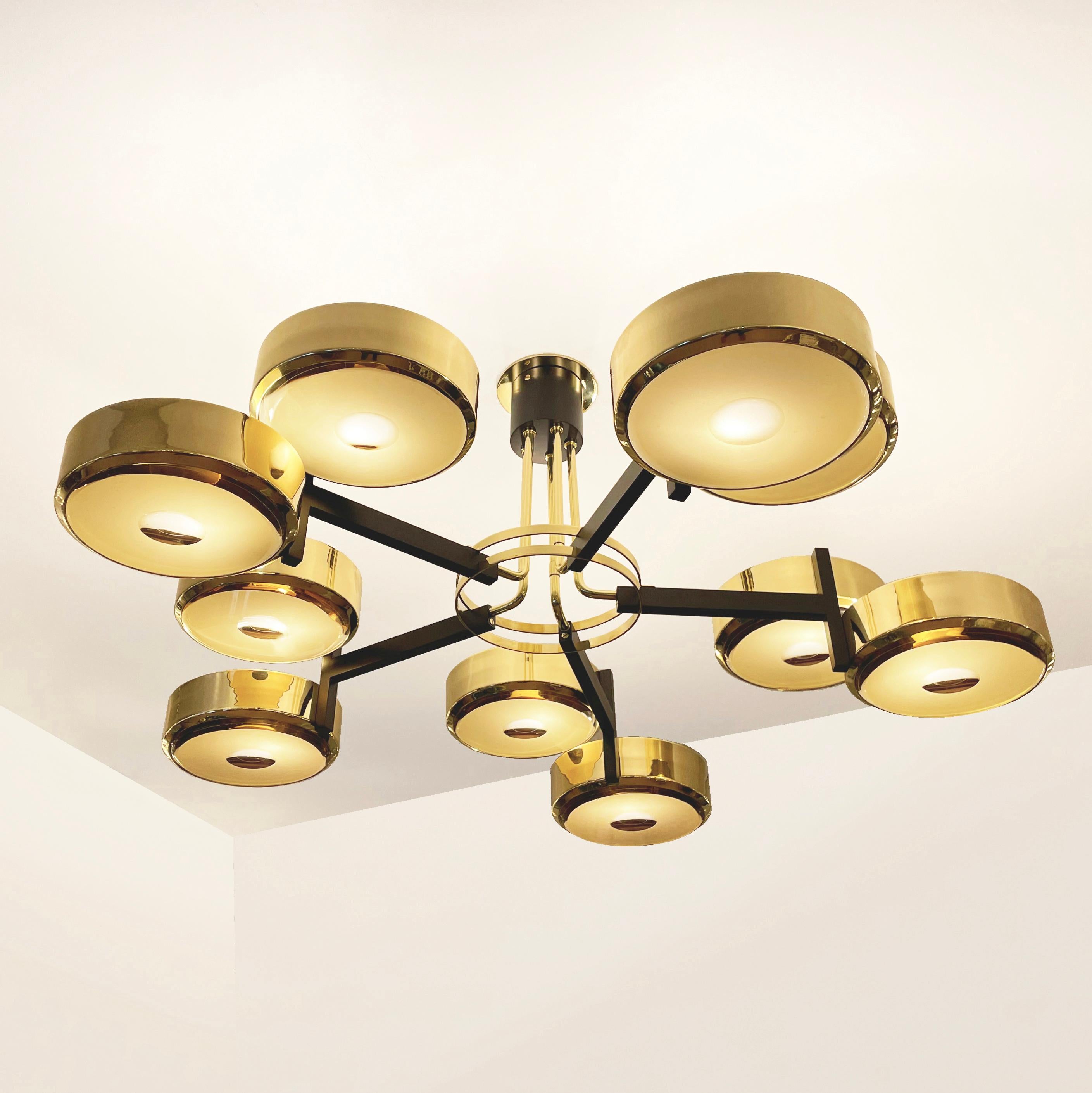 The Eclissi Grande ceiling light is designed around five pairs of eclipsing shades bound by a series of brass rings and a distinctive set of stems. Shown in polished brass with black accents and fitted with our Ambra Carved Glass.

Customization