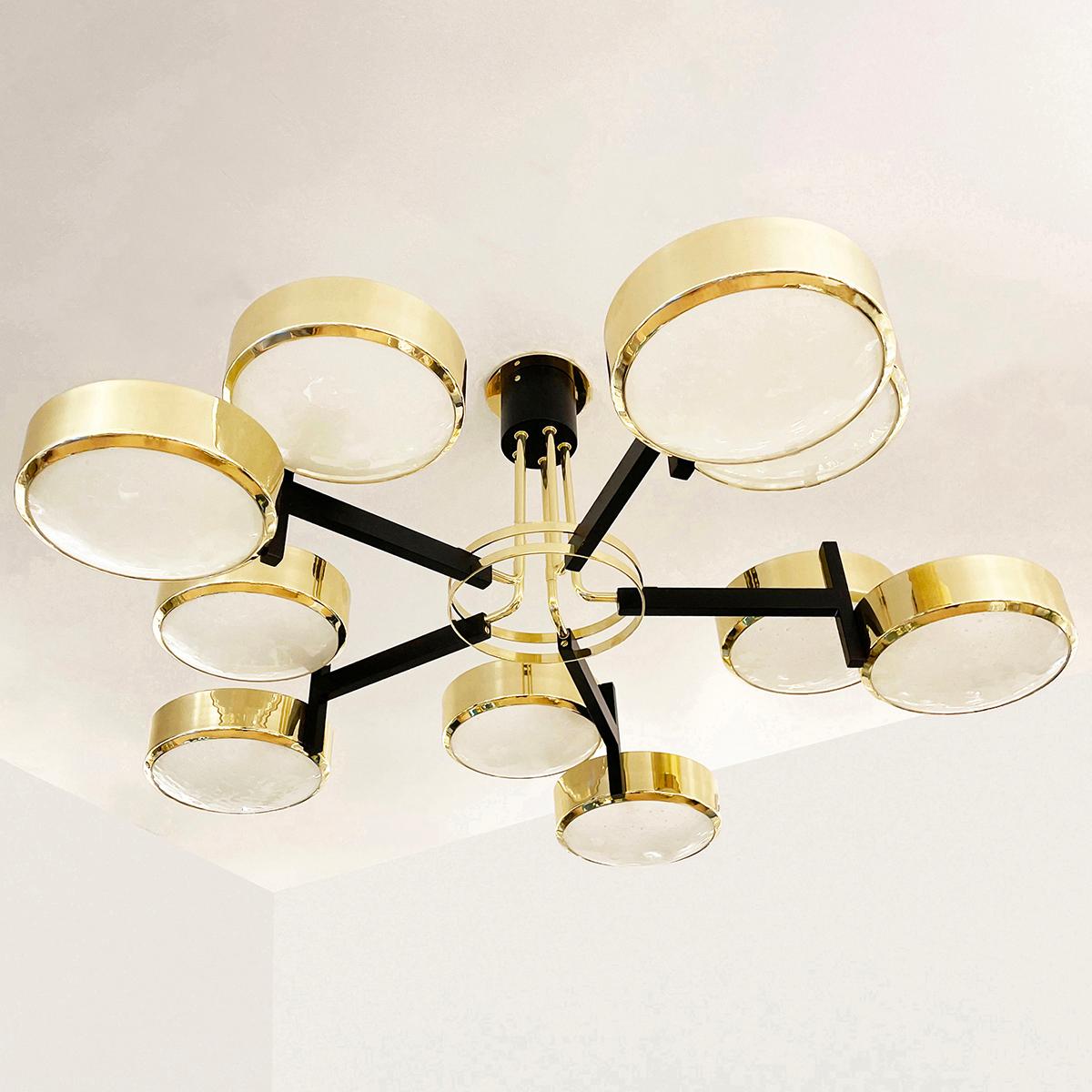 The Eclissi Grande ceiling light is designed around five pairs of eclipsing shades bound by a series of brass rings and a distinctive set of five stems. Shown in polished brass with black accents and fitted with our Murano Bubble