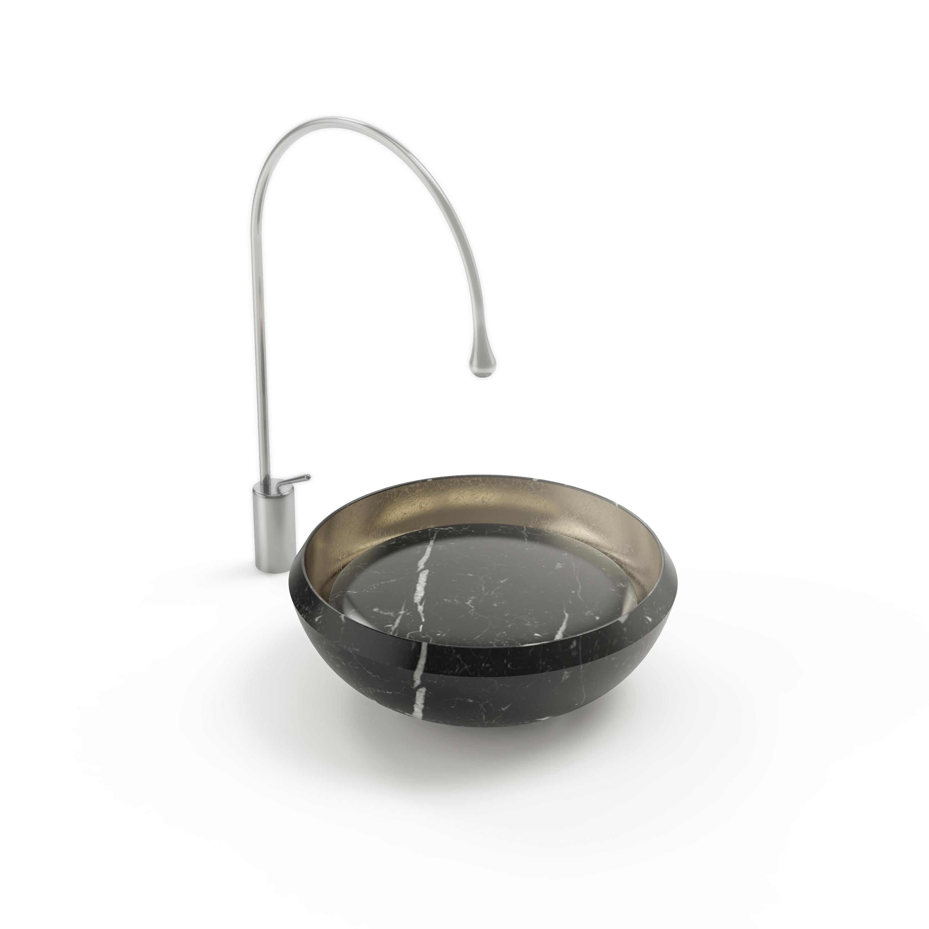 Eclissi washbasin by Marmi Serafini
Materials: Nero Marquinia marble, Gold Leaf.
Dimensions: D 47 x H 16 cm
Available in other marbles.
Tap not included.

As the sun, obscured by the moon during an eclipse, reveals an awe-striking fiery rim of